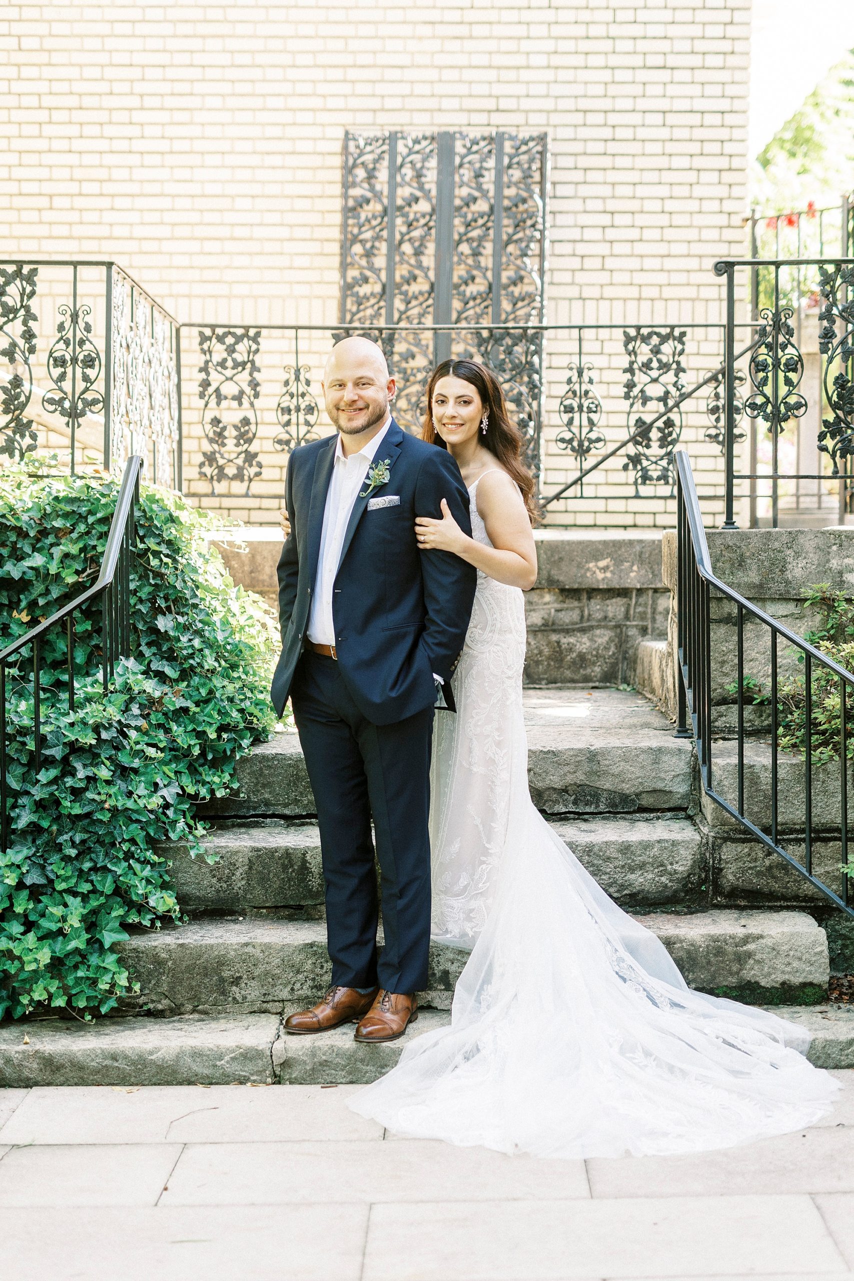 bride hugs groom from behind on steps at Separk Mansion