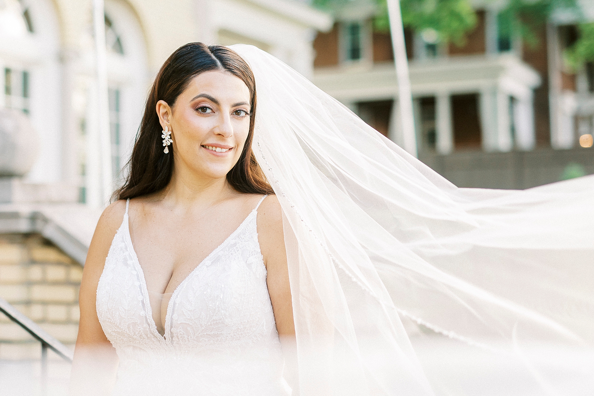 bride smiles with veil floating behind her