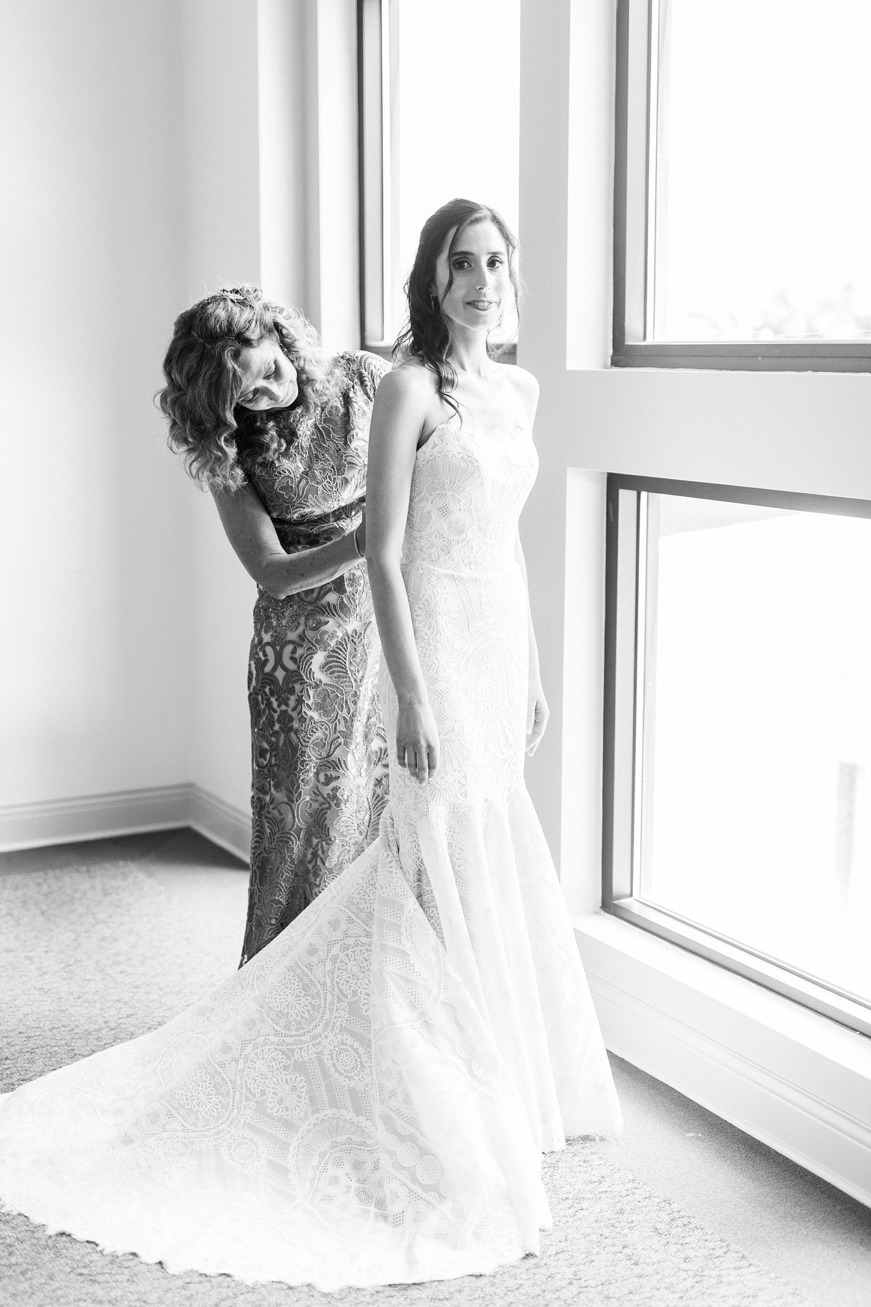 mother helps bride into wedding gown before Charlotte NC wedding