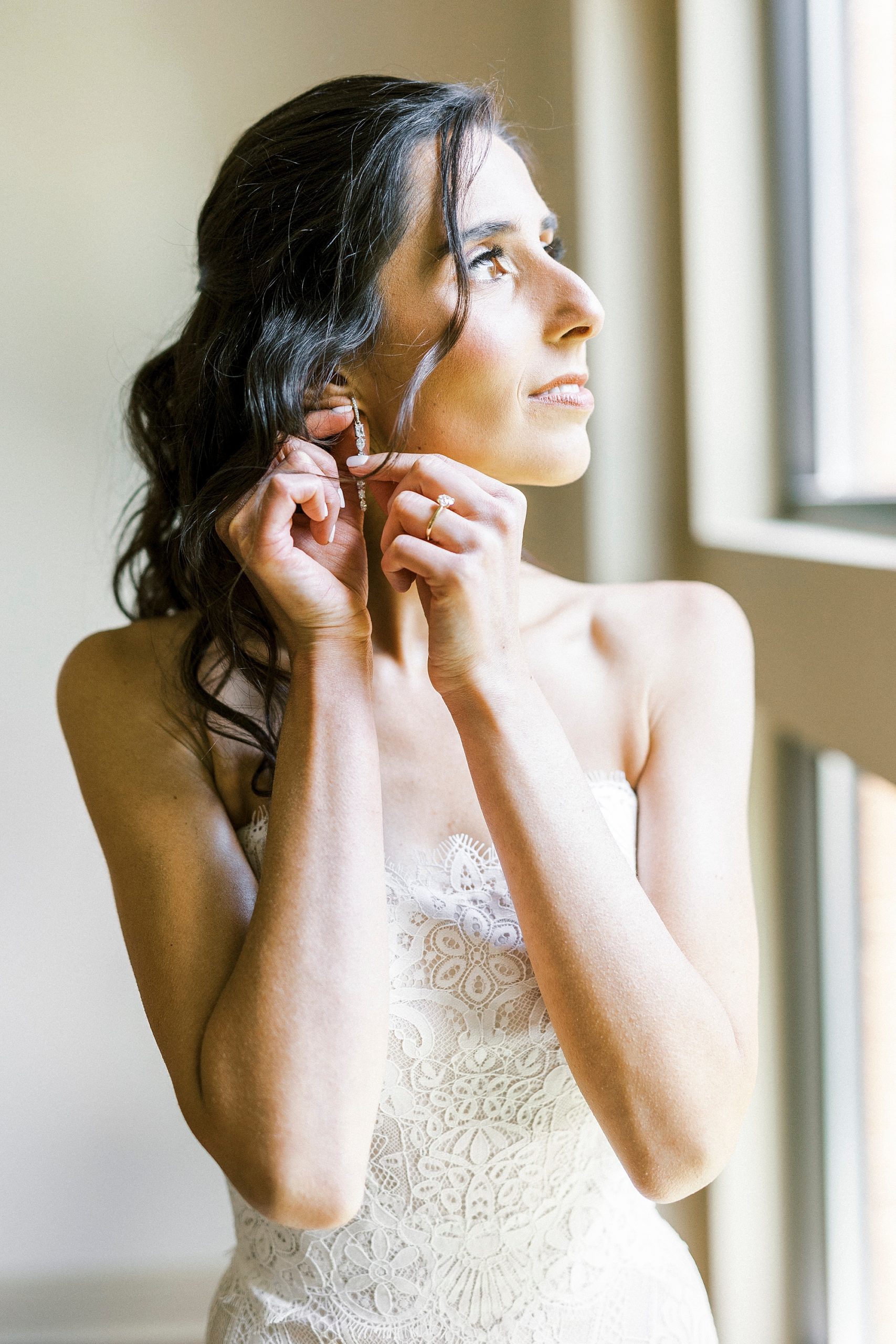 bride puts in earrings before Charlotte NC wedding