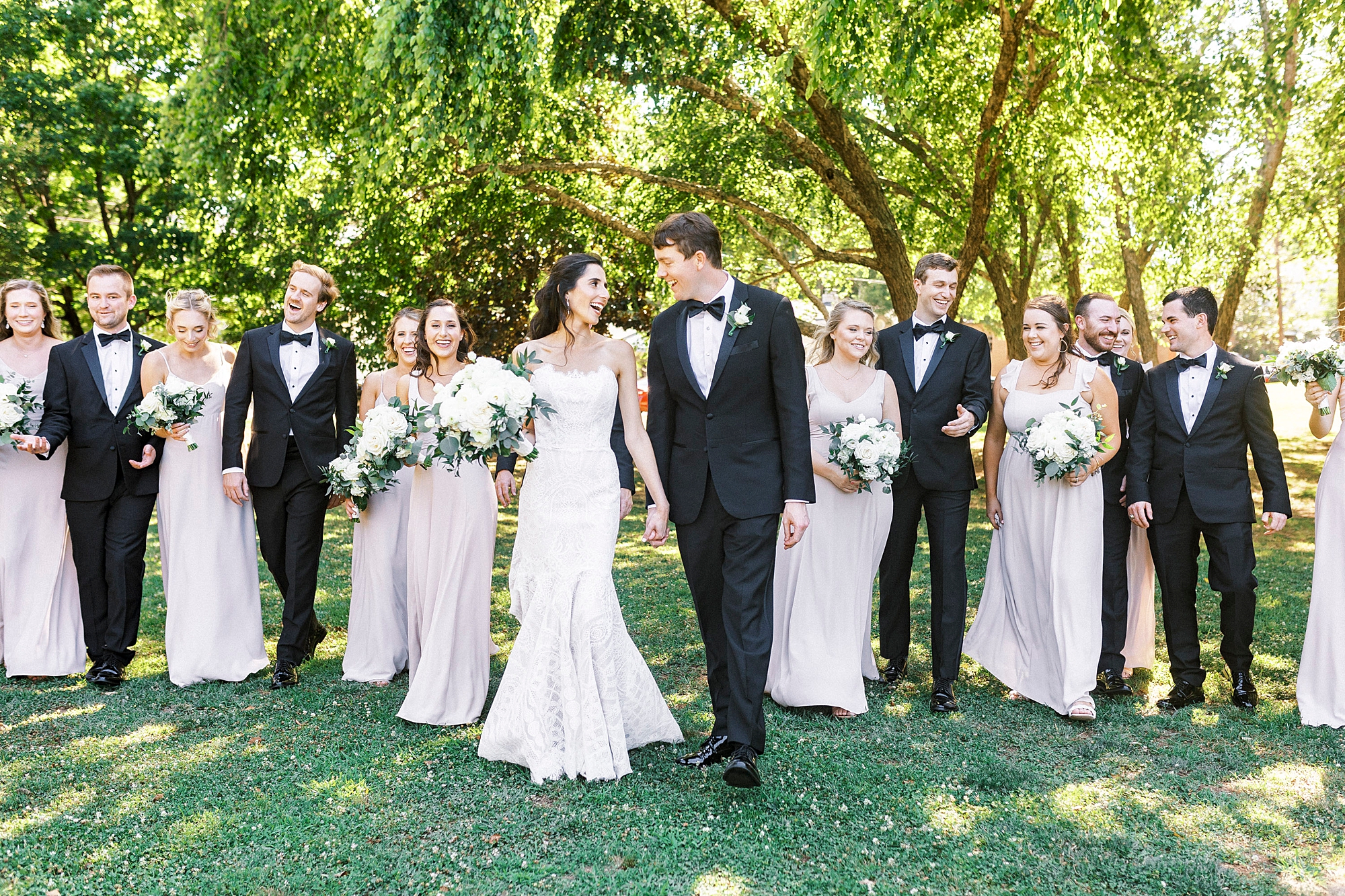 newlyweds walk with wedding party in Freedom Park