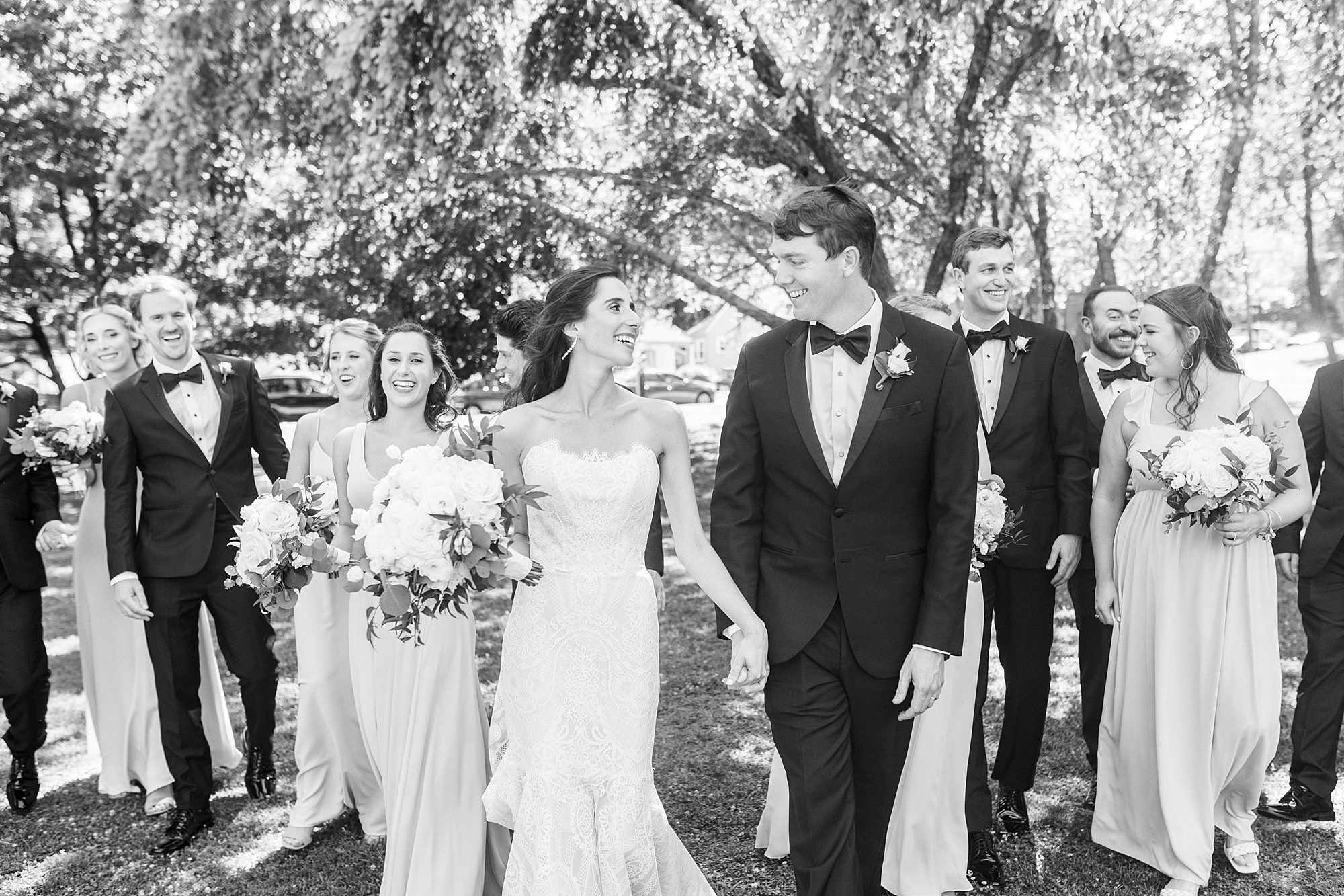 bride smiles at groom walking in front of wedding party at Freedom Park