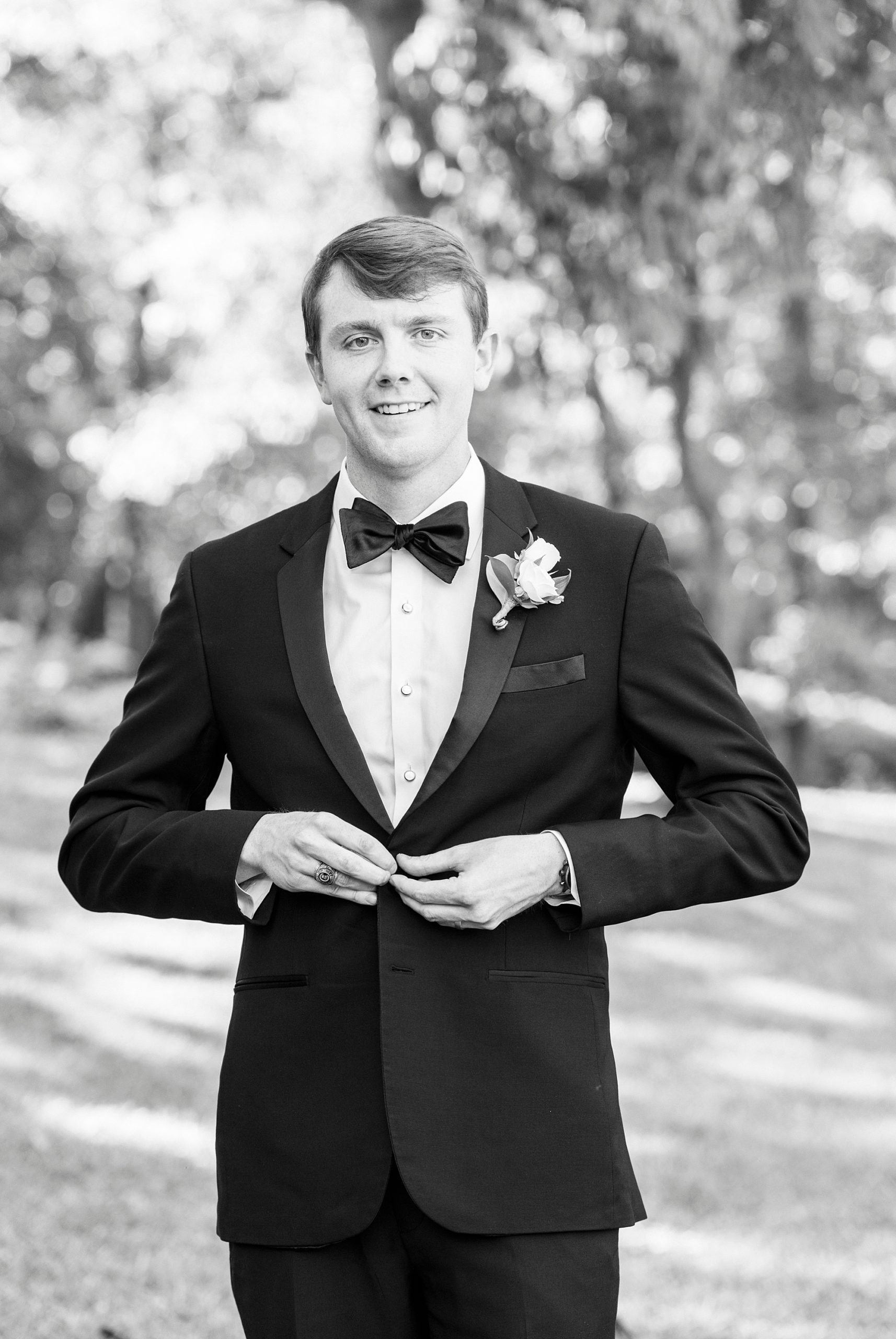 groom adjusts classic tux jacket in Charlotte NC