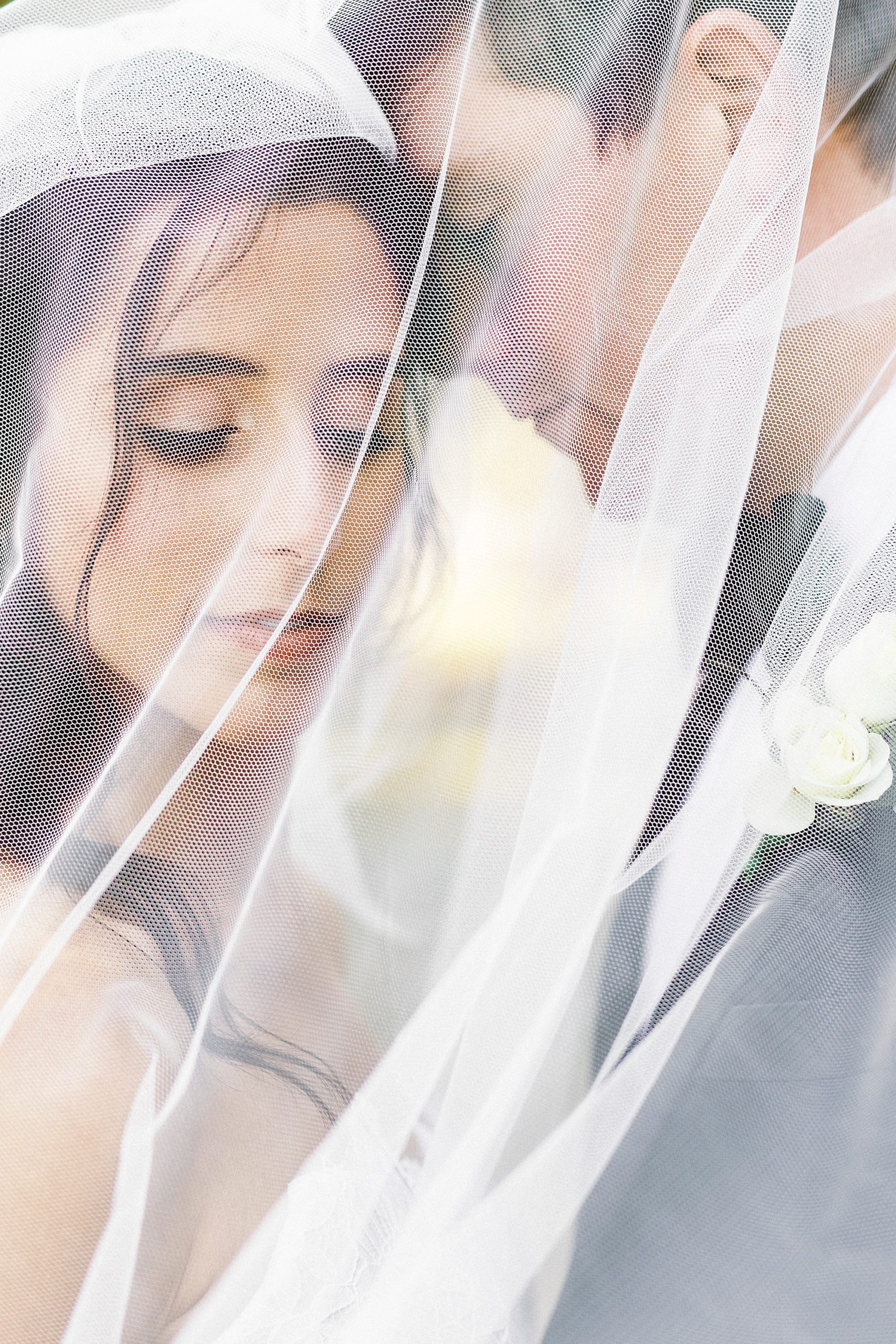 groom leans into bride's forehead during Charlotte NC wedding photos under veil