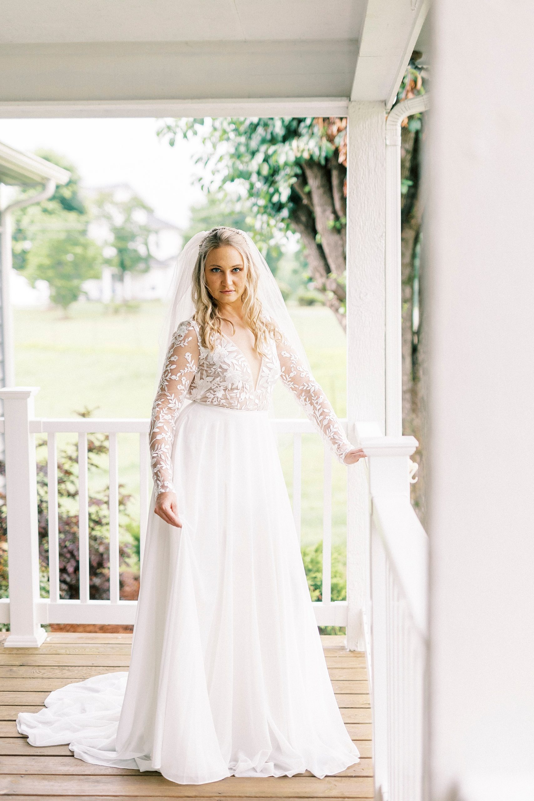 bride smiles leaning against railing in Lenoir NC