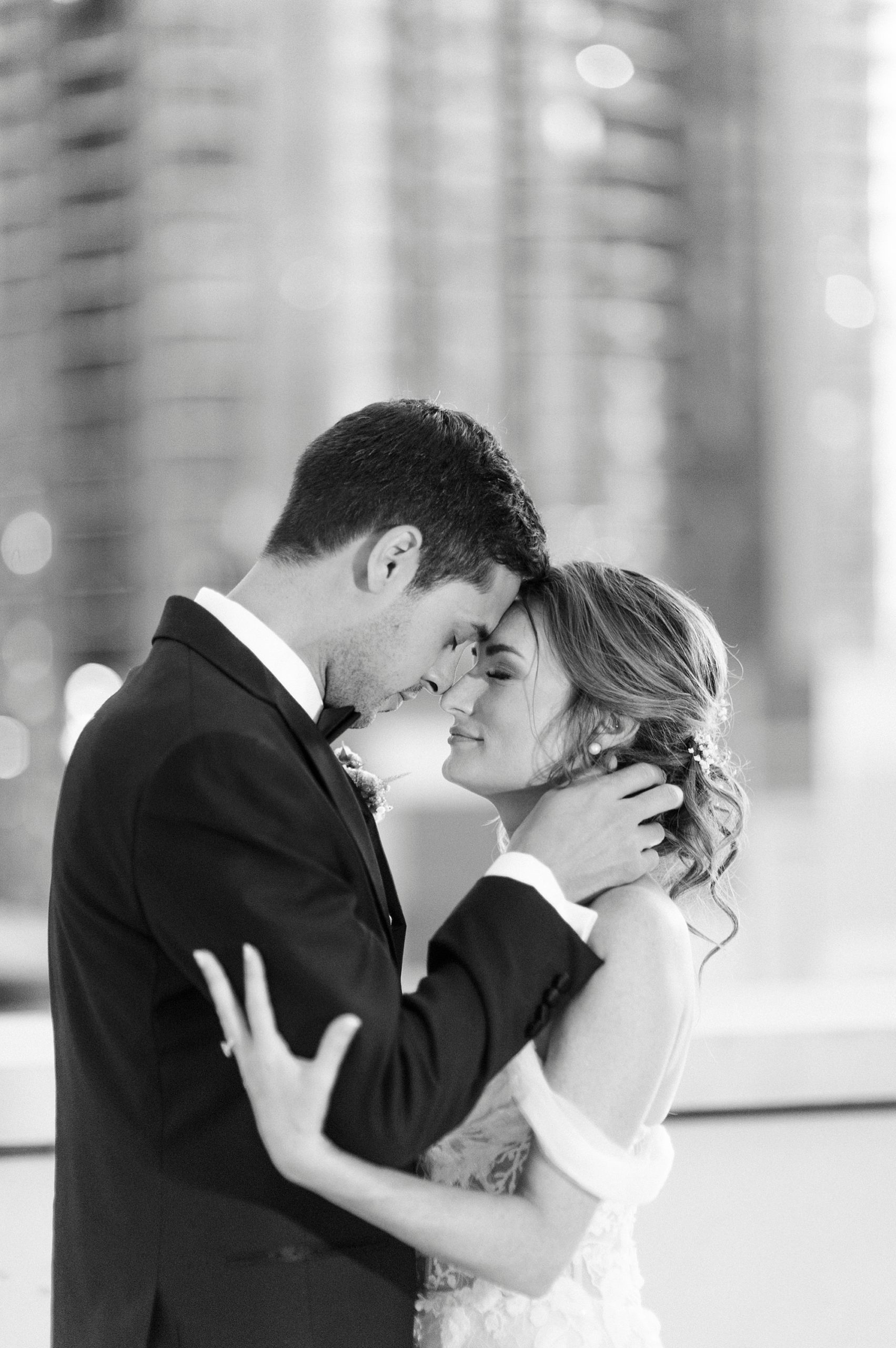 newlyweds lean heads together on rooftop at The Grand Bohemian Hotel