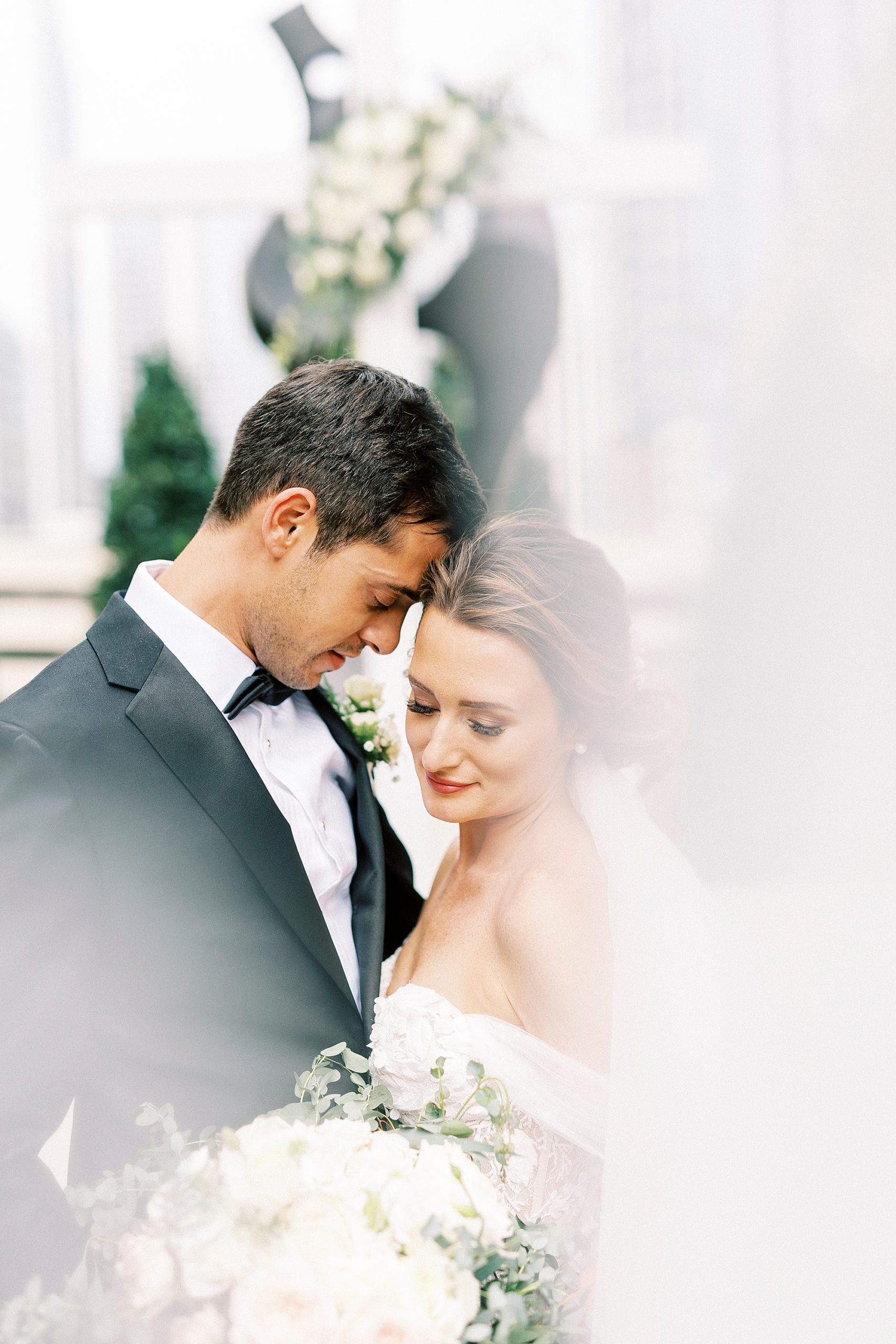 bride and groom lean heads together during NC wedding portraits
