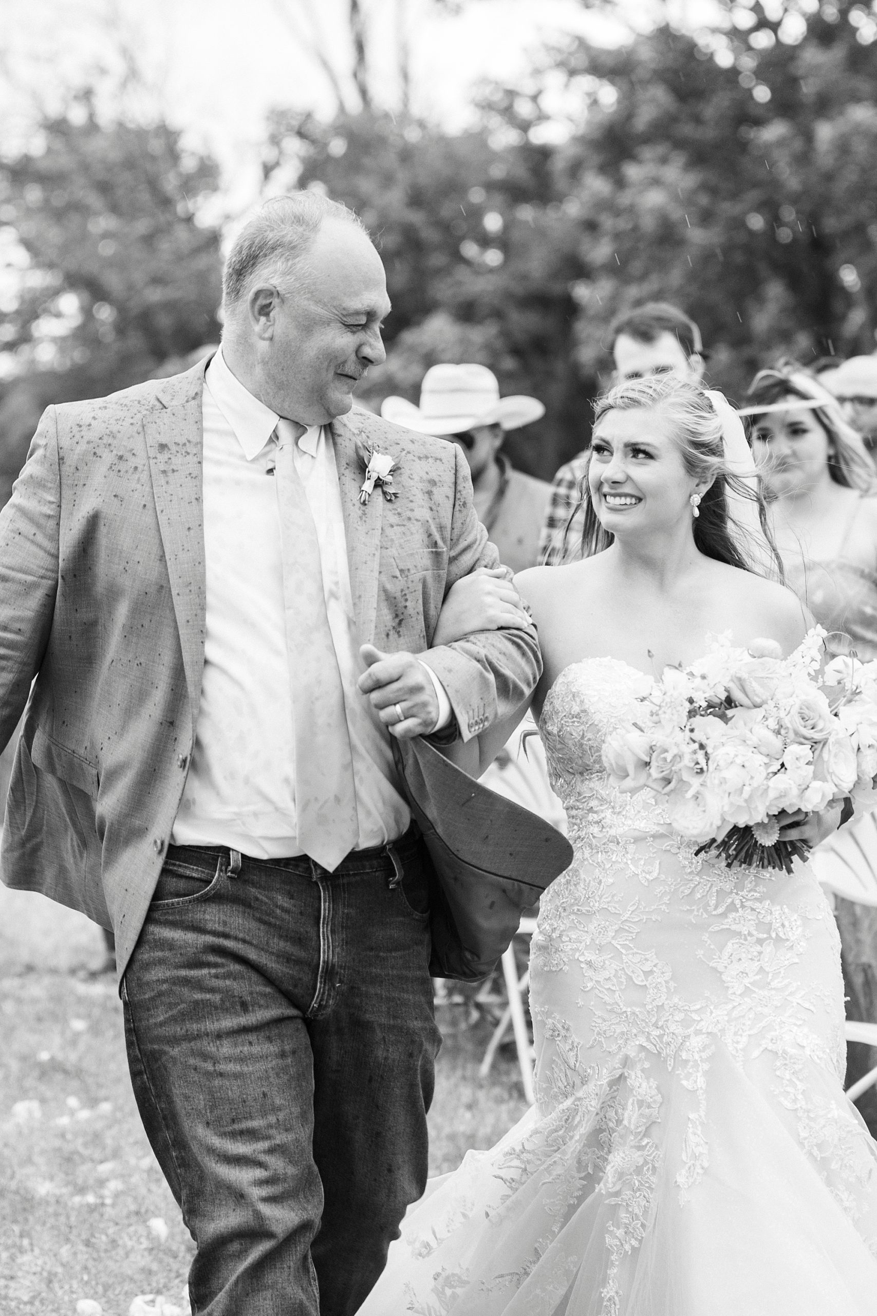 bride smiles at dad during rainy wedding ceremony at The Stable at Riverview