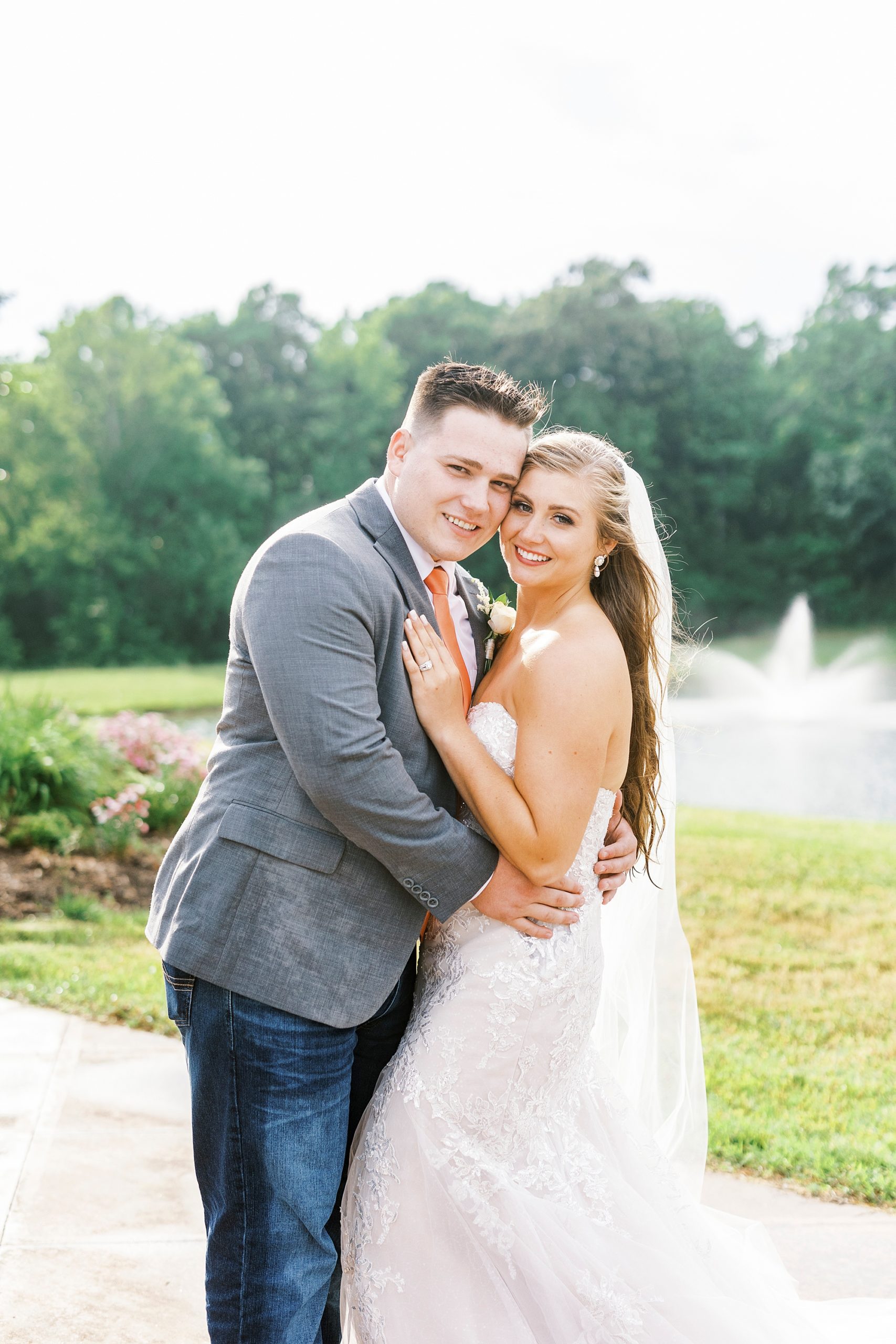bride and groom hug by pond at The Stable at Riverview