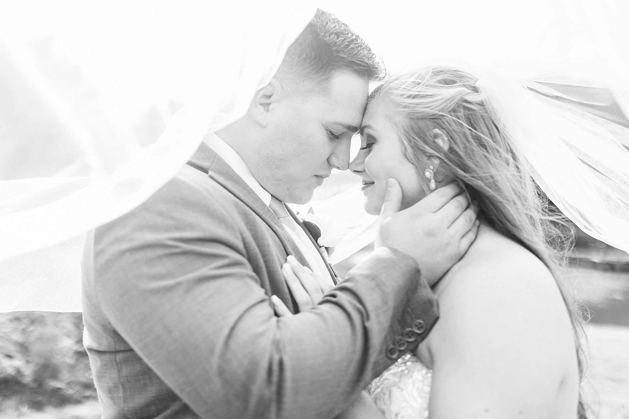 groom holds bride's neck bringing her close to him