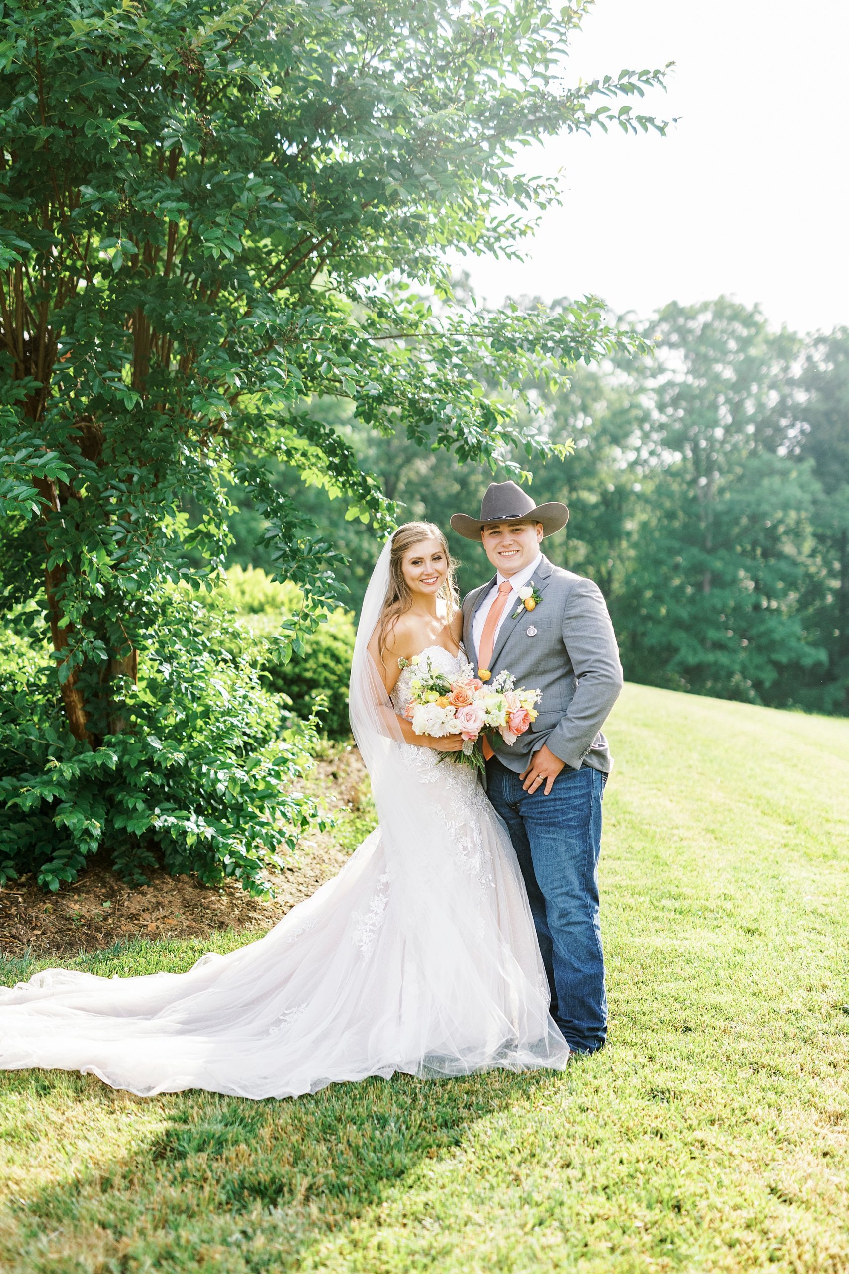 bride and groom stand on lawn at The Stable at Riverview