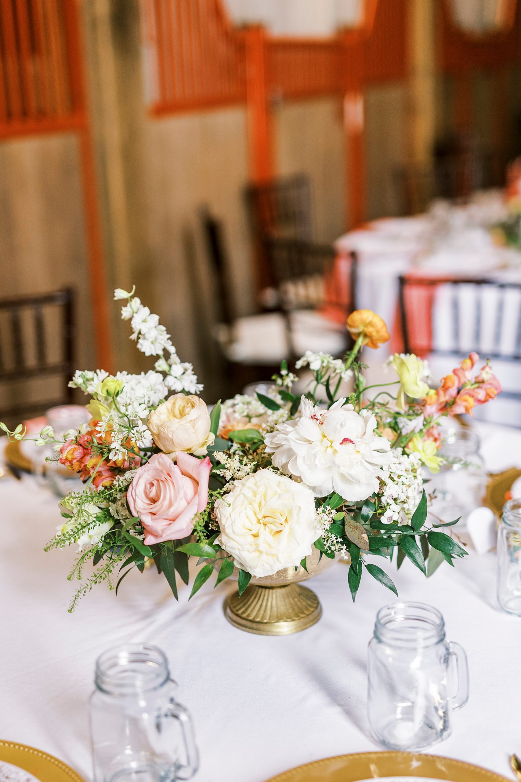 white and pink floral centerpieces in gold vase at The Stable at Riverview