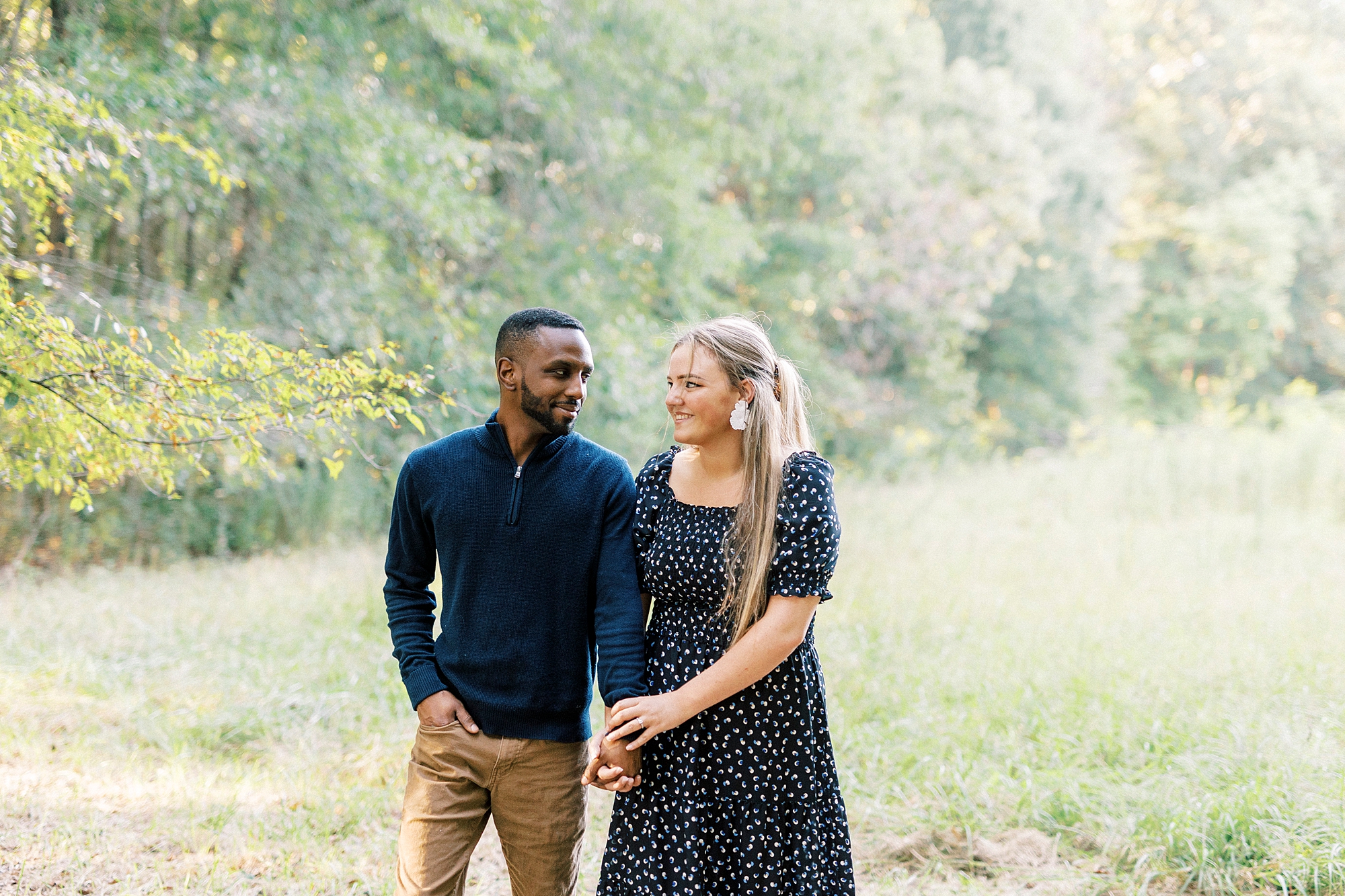 engaged couple holds hands walking through Bella Terra