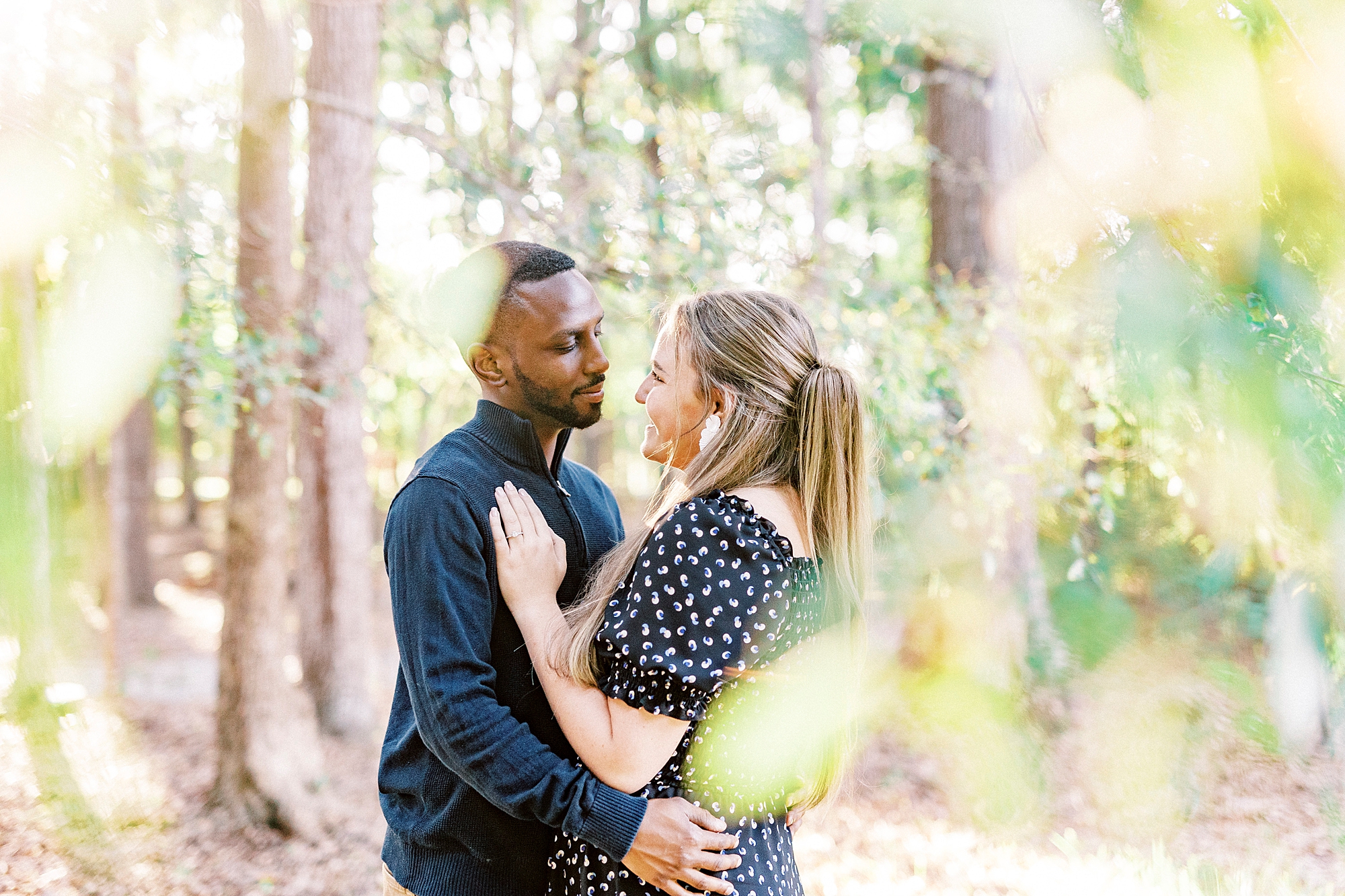 couple hugs among tree branches at Bella Terra