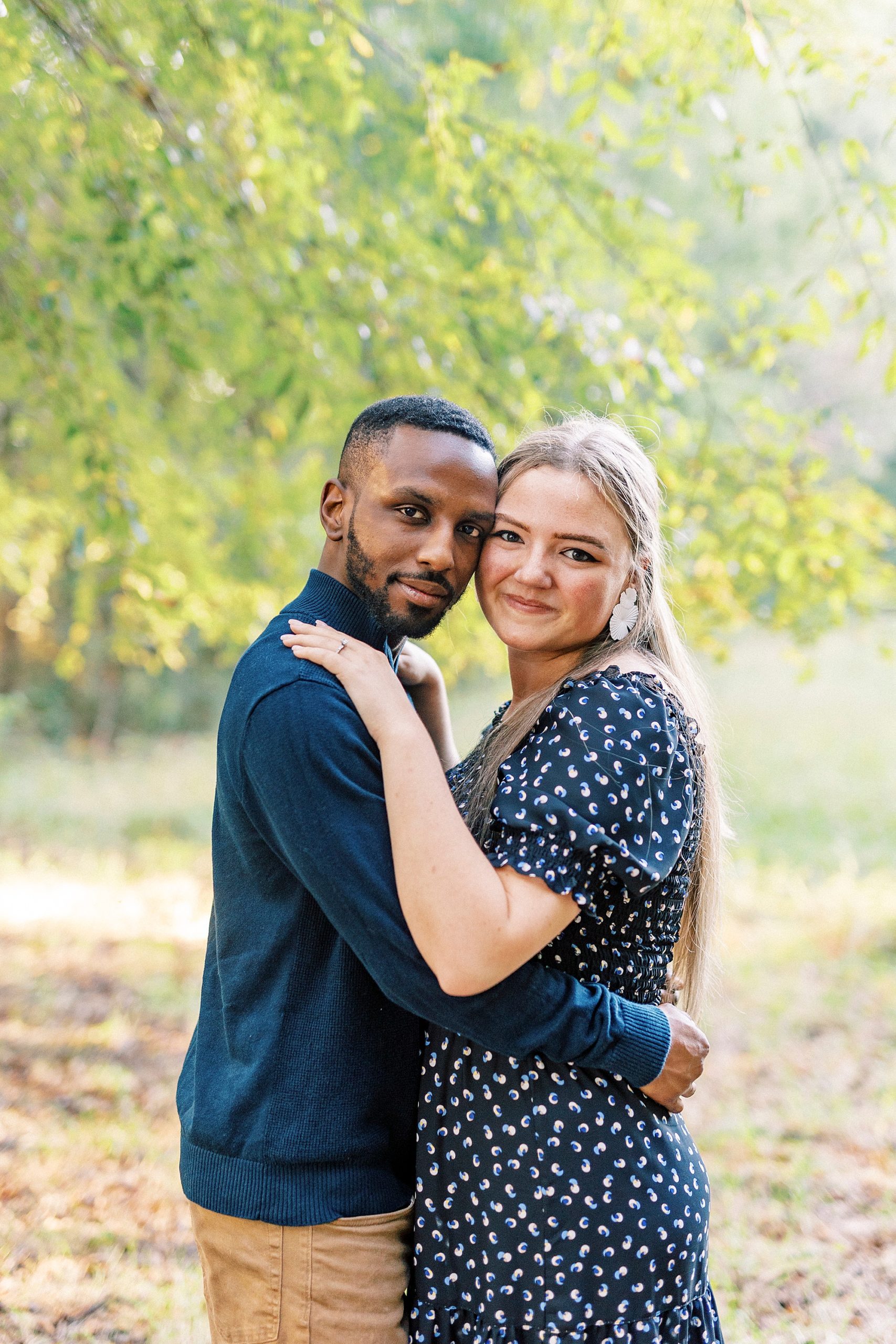 engaged couple hugs among fall trees at Bella Terra