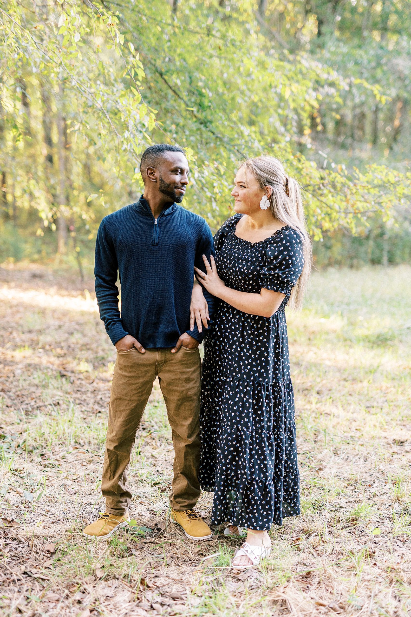 bride in navy gown smiles at groom during Bella Terra engagement session