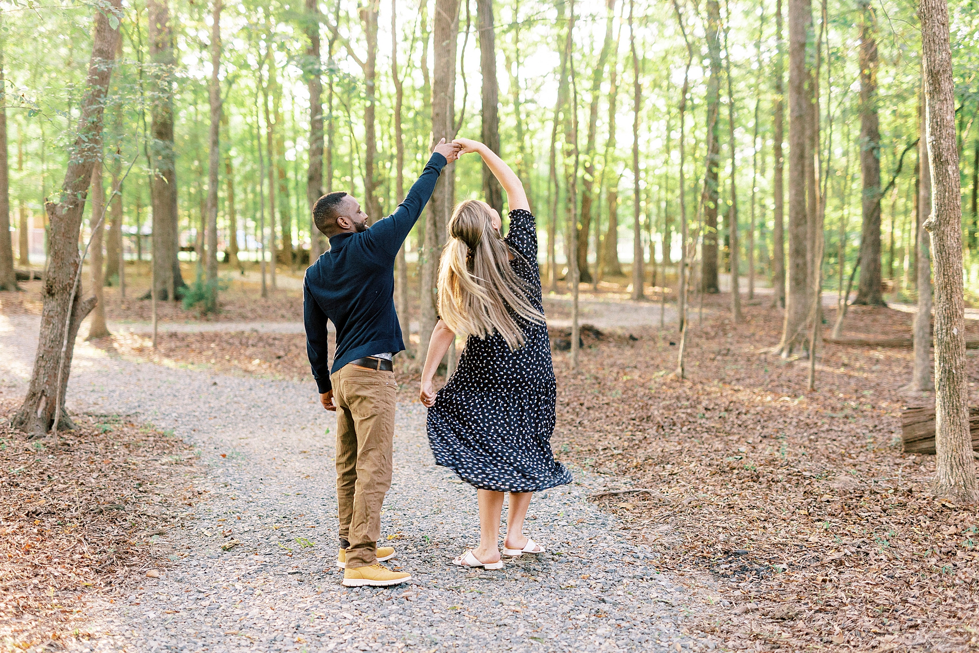 groom twirls fiancee during fall engagement photos