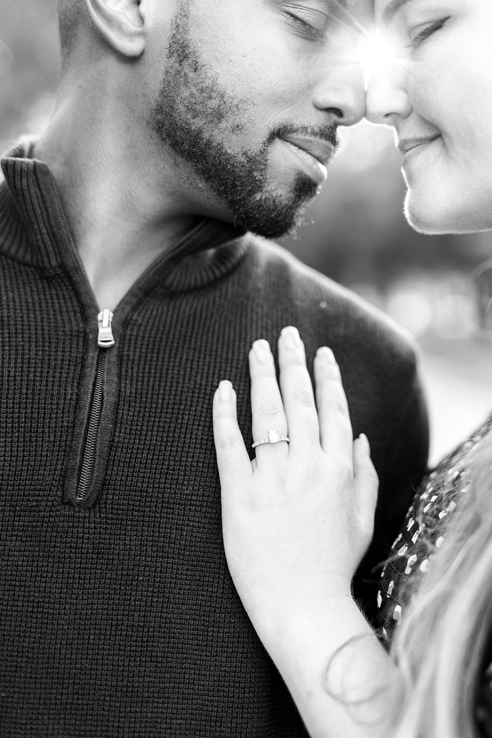 woman shows off engagement ring on fiancee's chest
