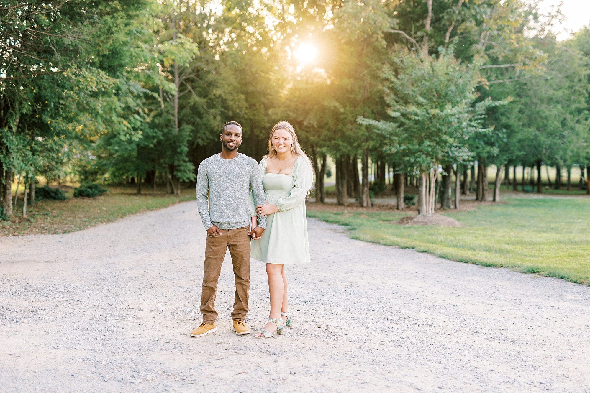 couple stands together on pathway in pastel outfits at Bella Terra