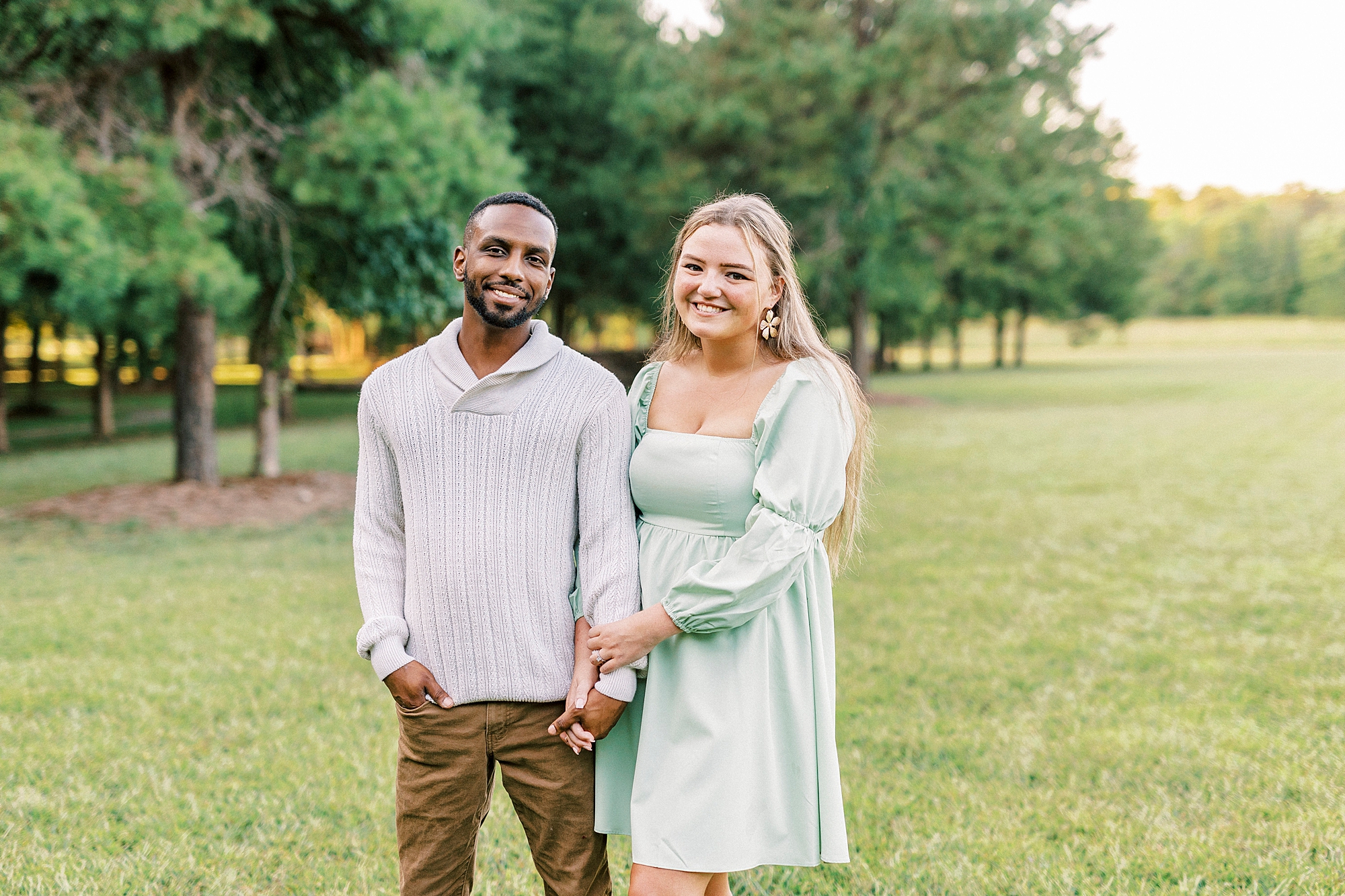 couple holds hands standing on lawn at Bella Terra
