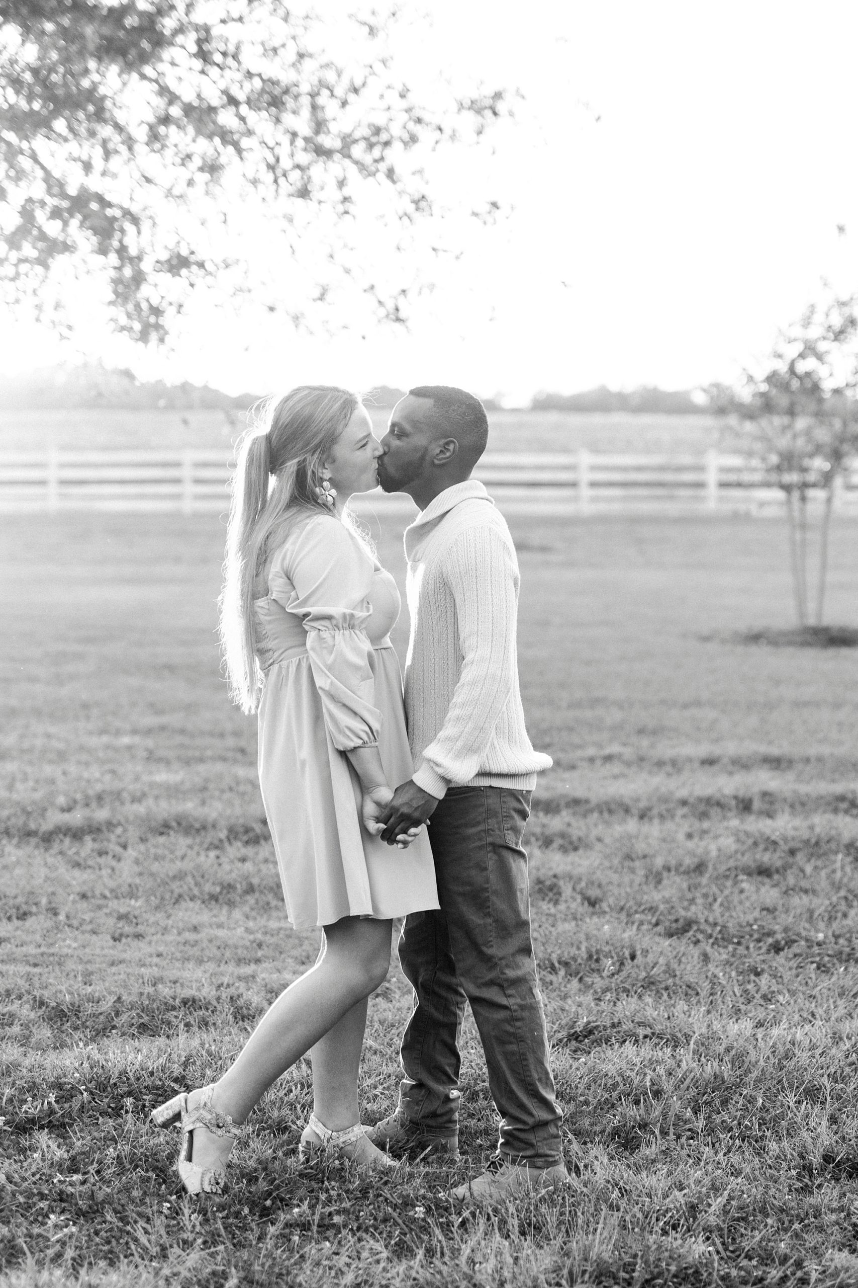 engaged couple kisses on lawn at Bella Terra