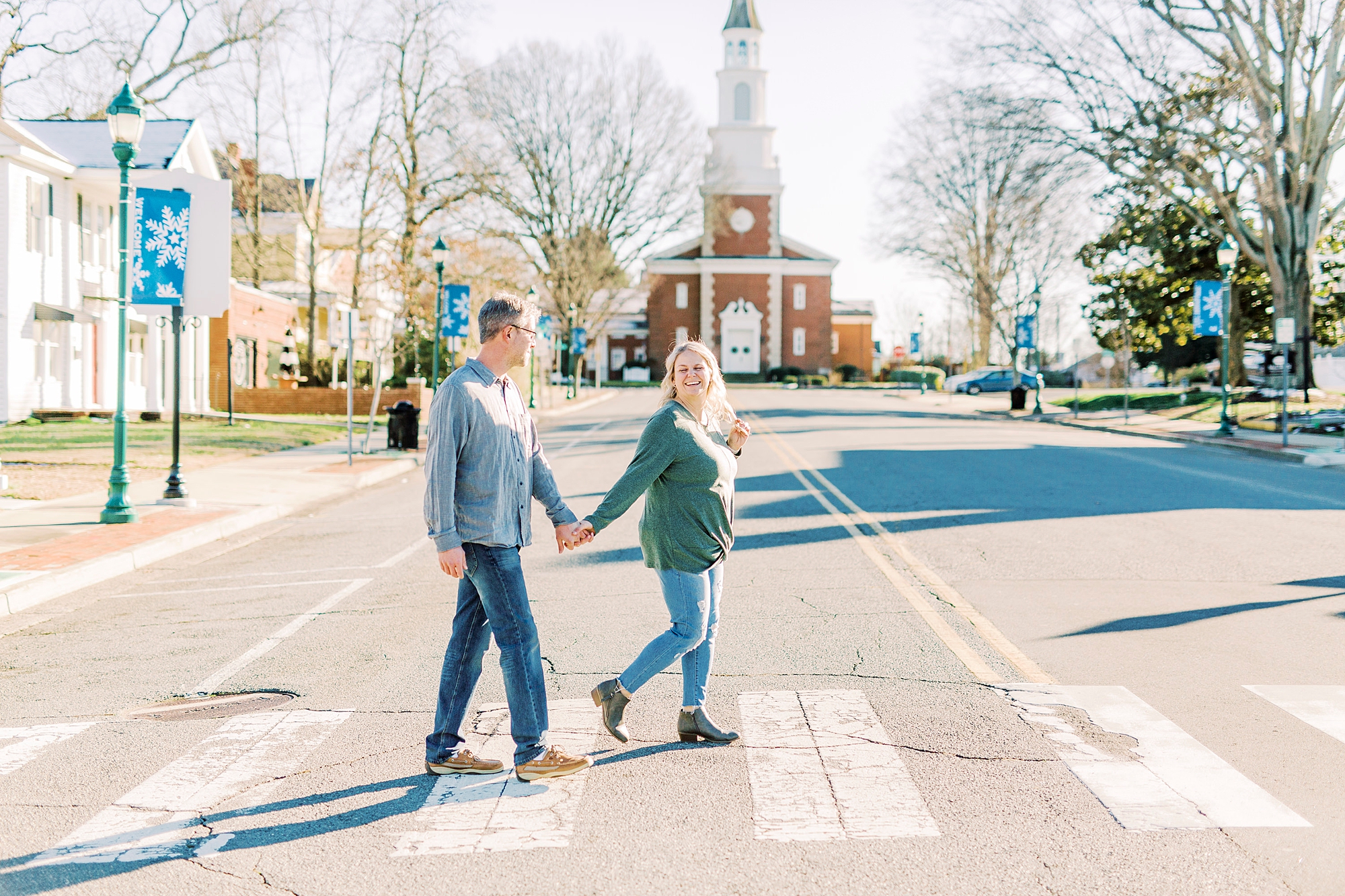 bride and groom walk through streets during Downtown Monroe engagement portraits