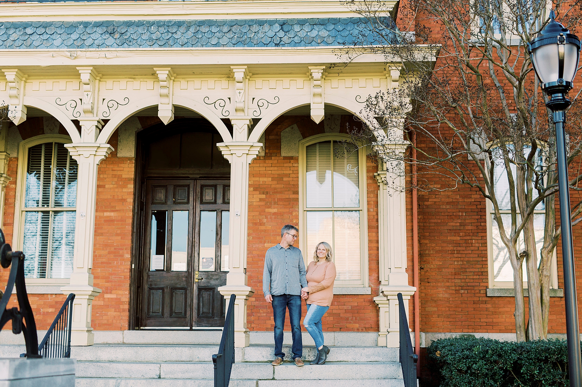 bride and groom pose on steps during Downtown Monroe engagement portraits