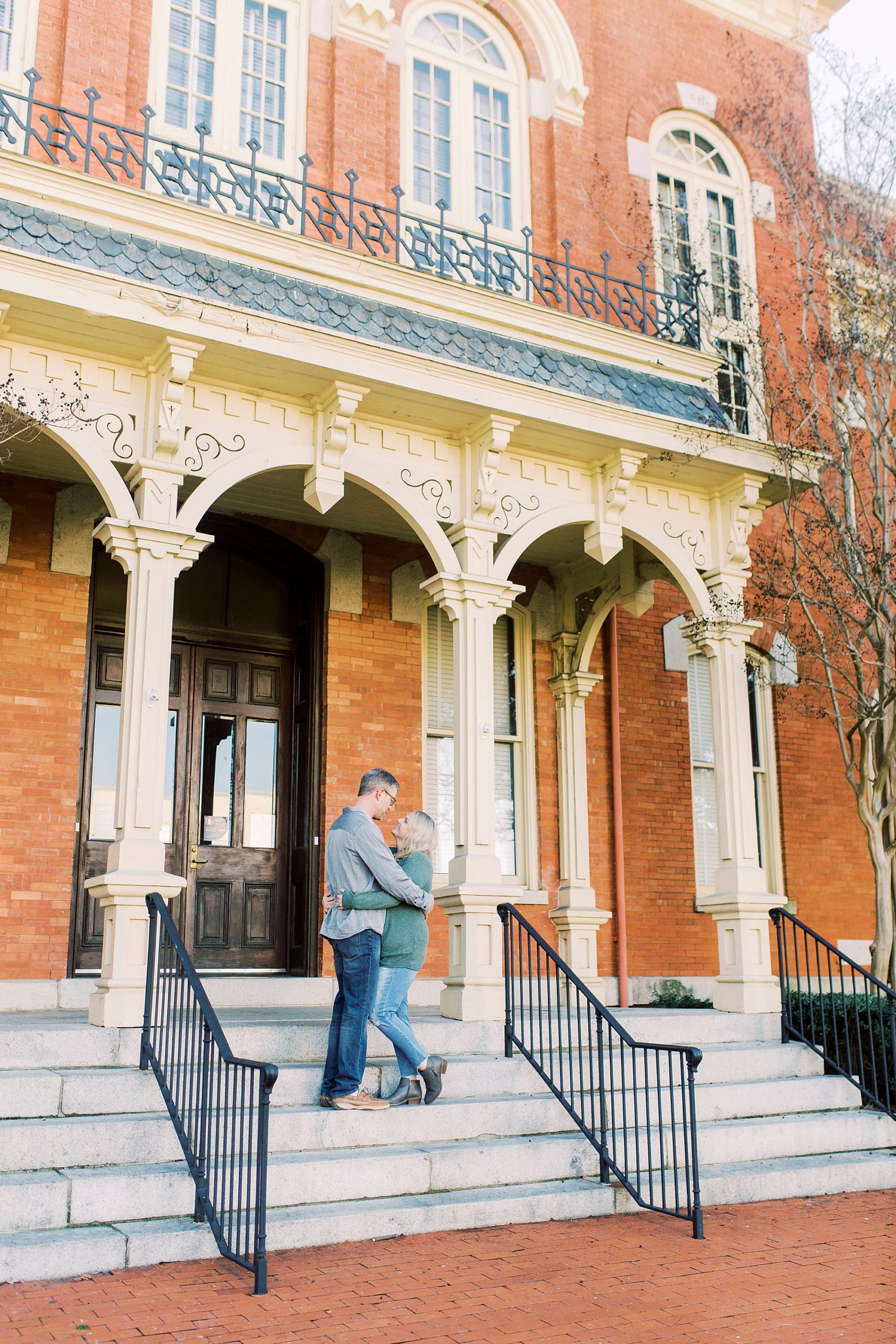 bride and groom stand on steps during Downtown Monroe engagement portraits