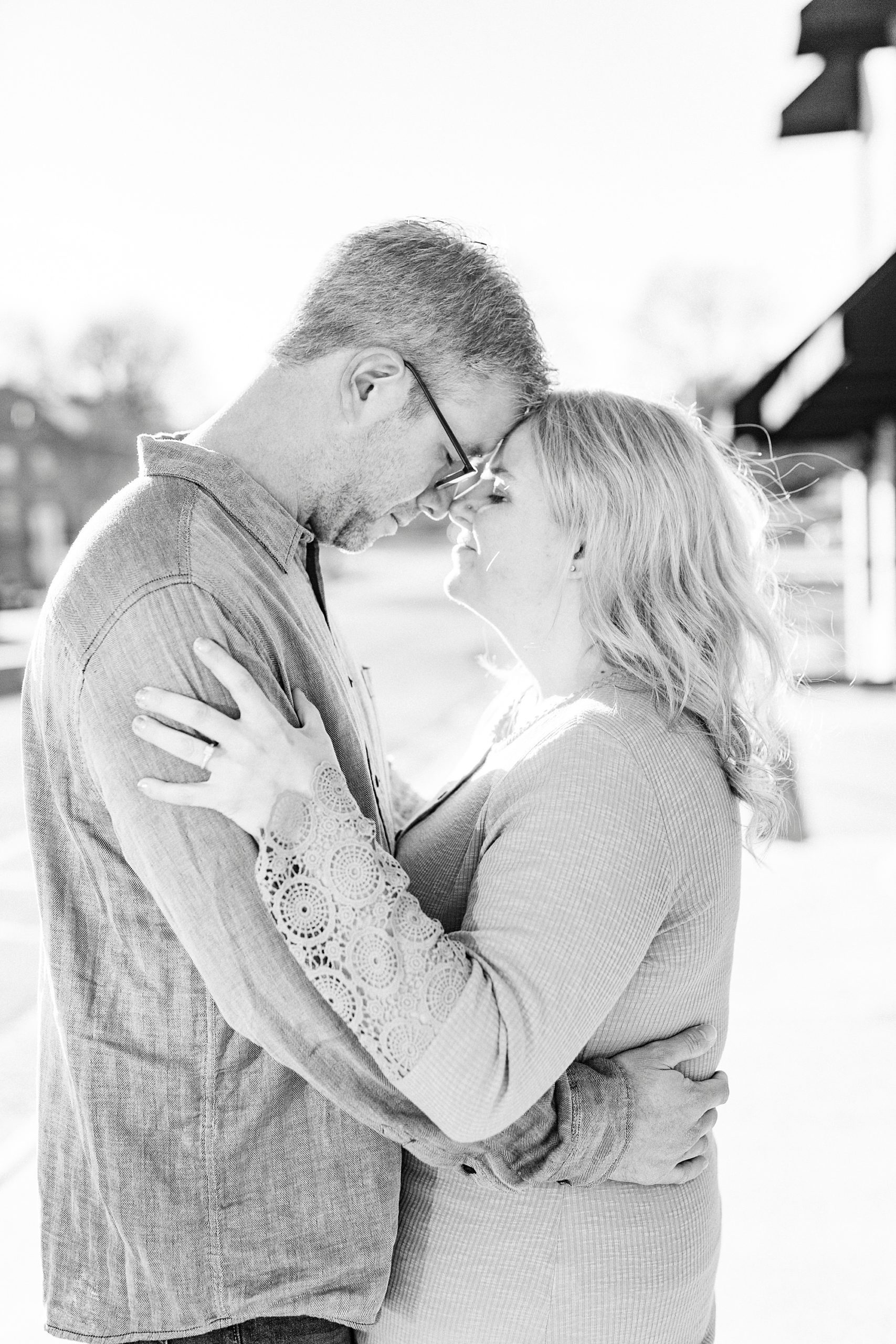 bride and groom lean heads together during Downtown Monroe engagement portraits