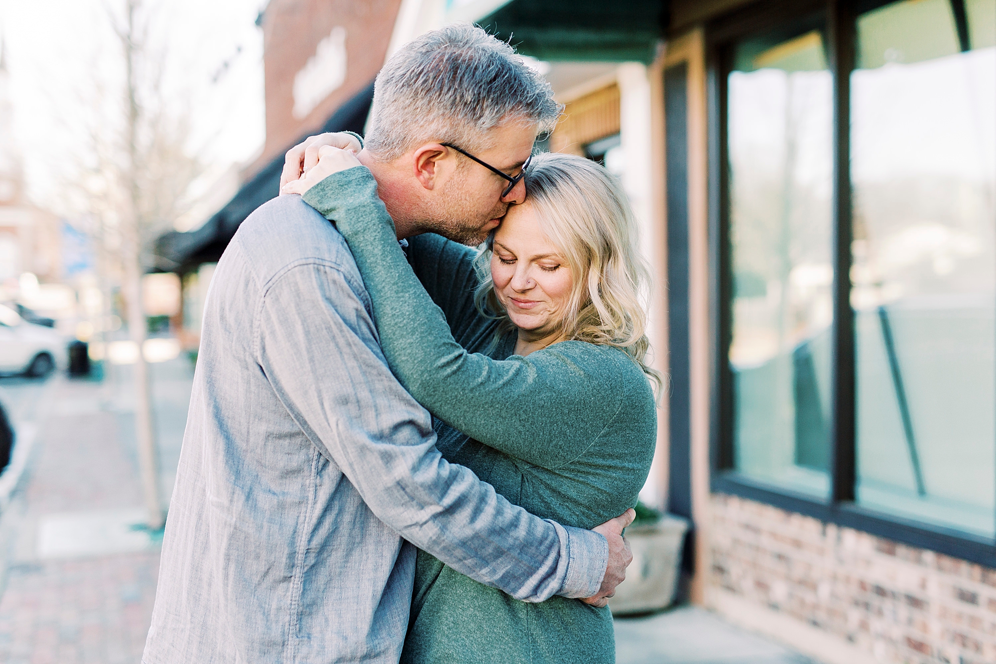 groom hugs bride during cozy Downtown Monroe engagement portraits