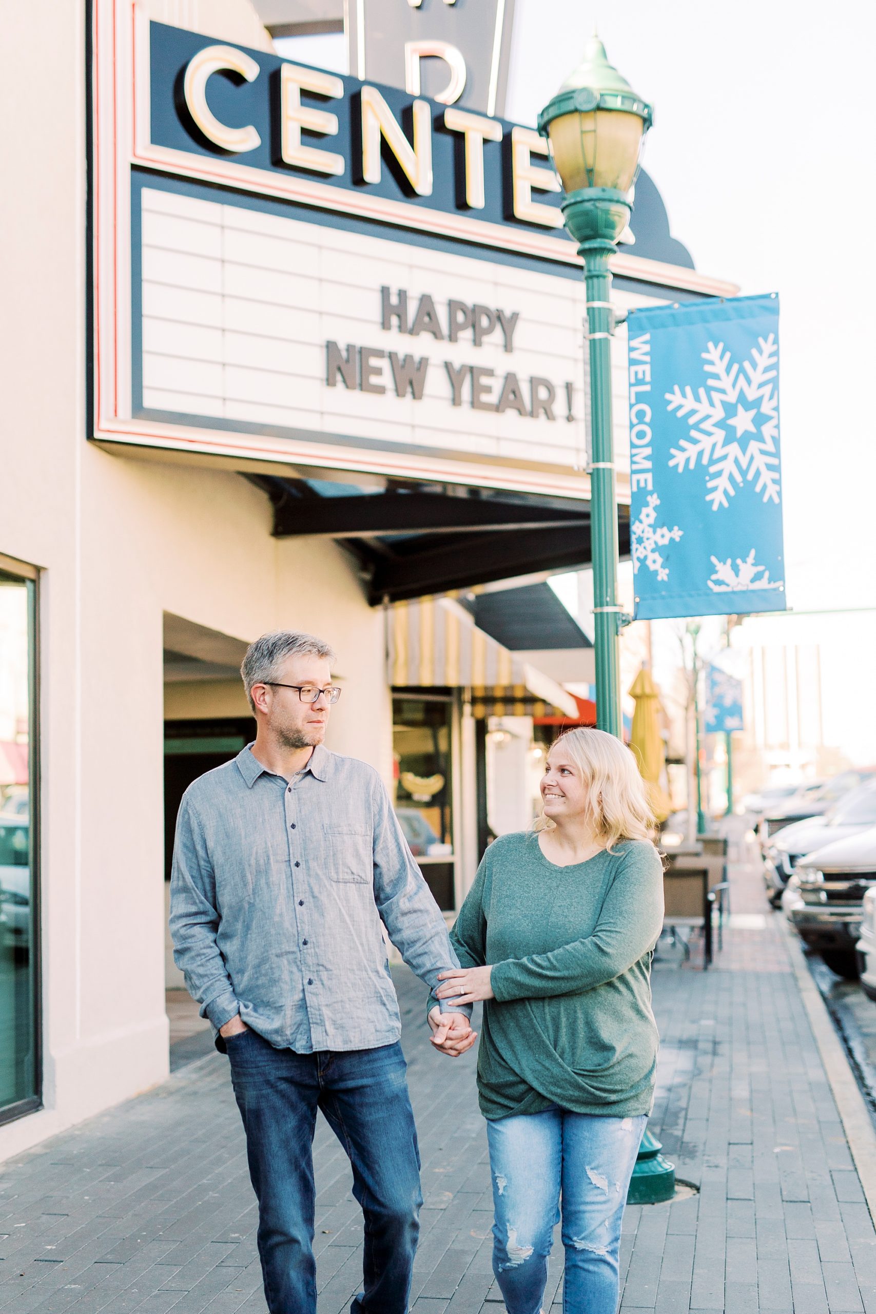 engaged couple walks down street during fall Downtown Monroe engagement portraits