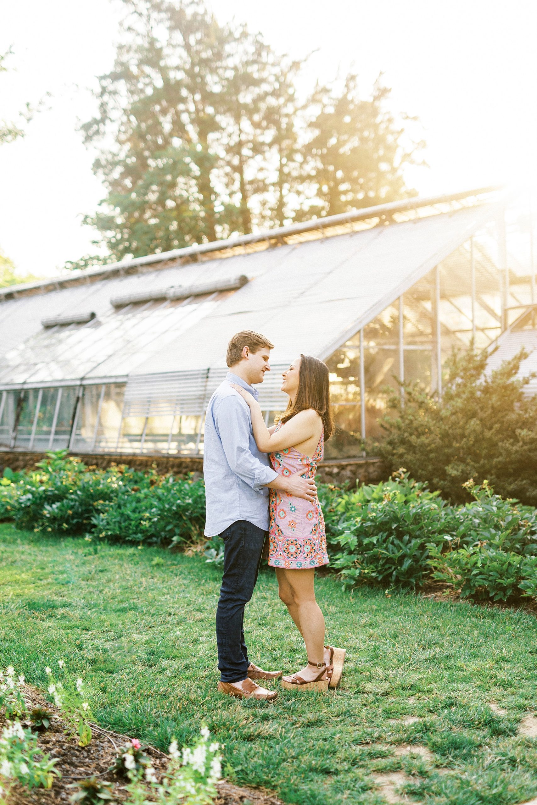 sunset portrait for man and woman by greenhouse at Reynolda Gardens