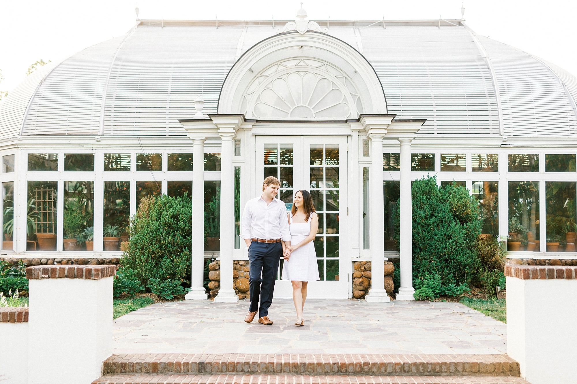 engaged couple walks o brick patio at Reynolda Gardens