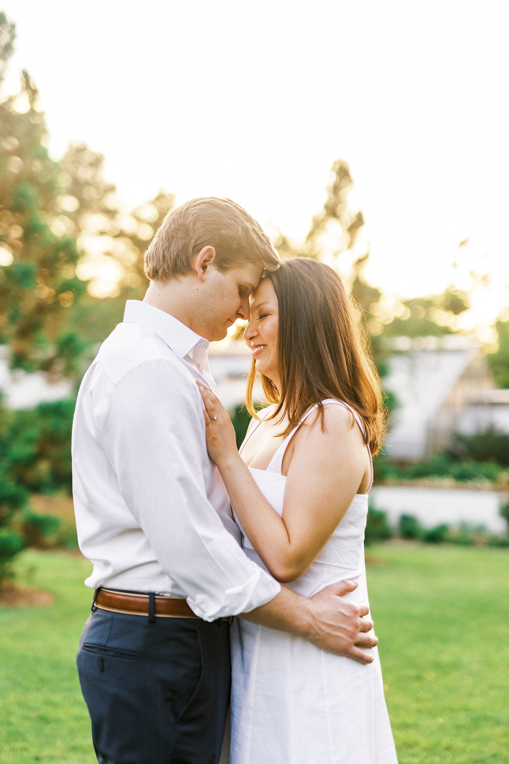 couple leans heads together during sunset at Reynolda Gardens