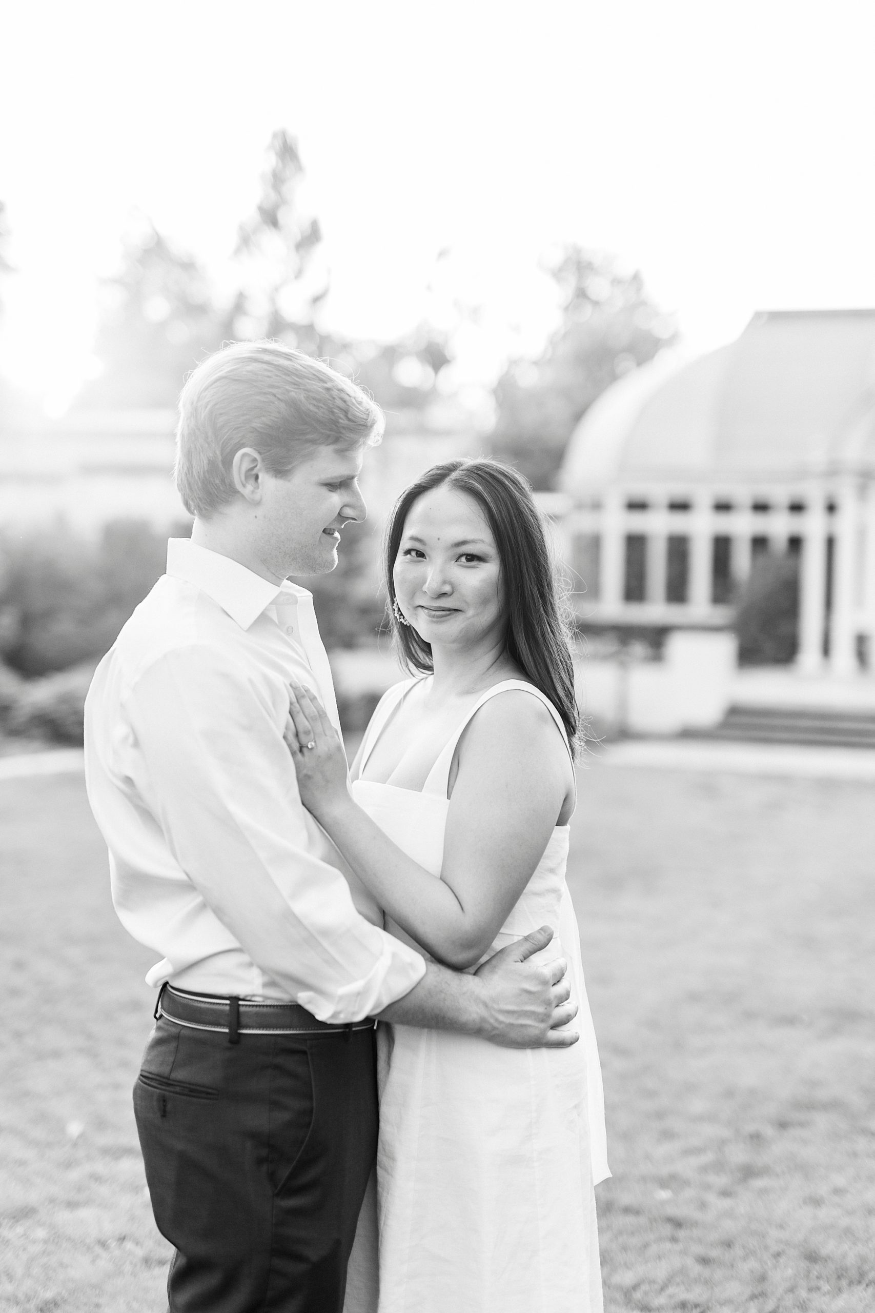 man looks at woman holding her on lawn at Reynolda Gardens