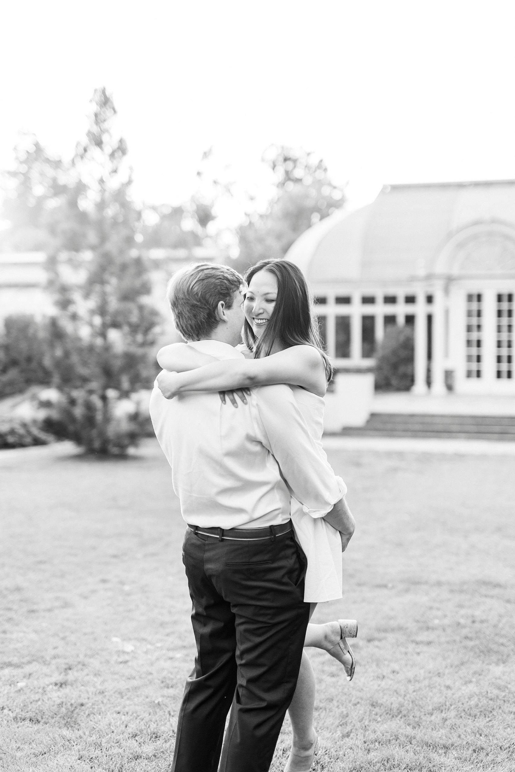 groom lifts up bride on lawn of Reynolda Gardens