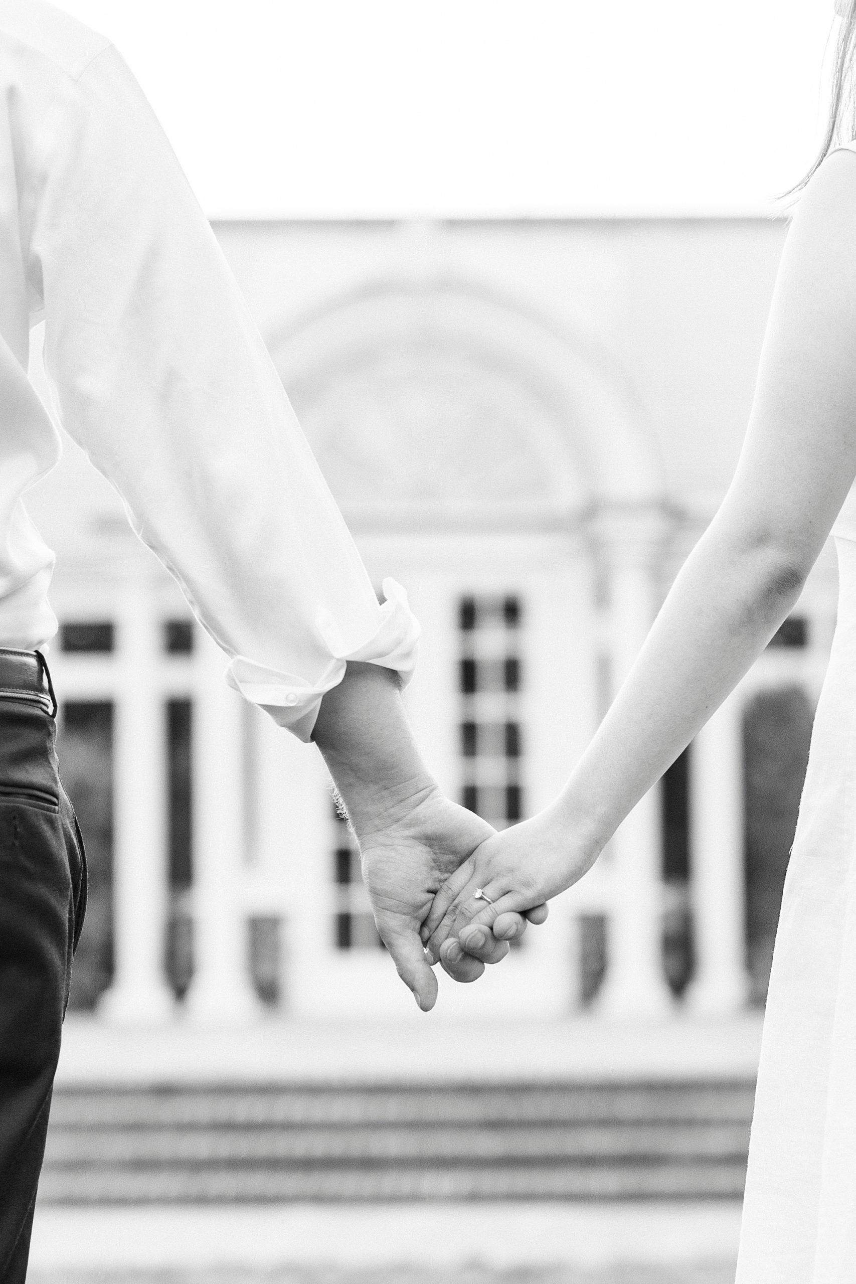 couple holds hands by conservatory at Reynolda Gardens