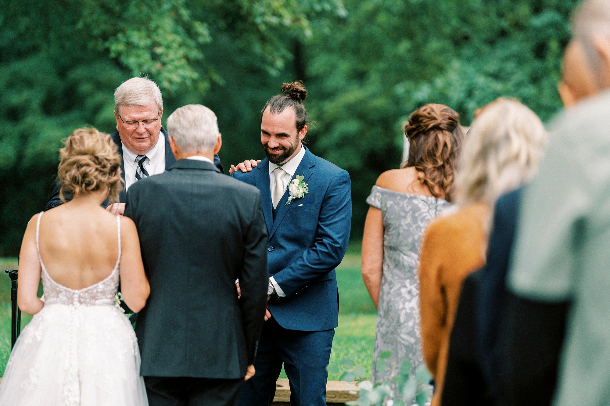 groom smiles at bride entering wedding ceremony 