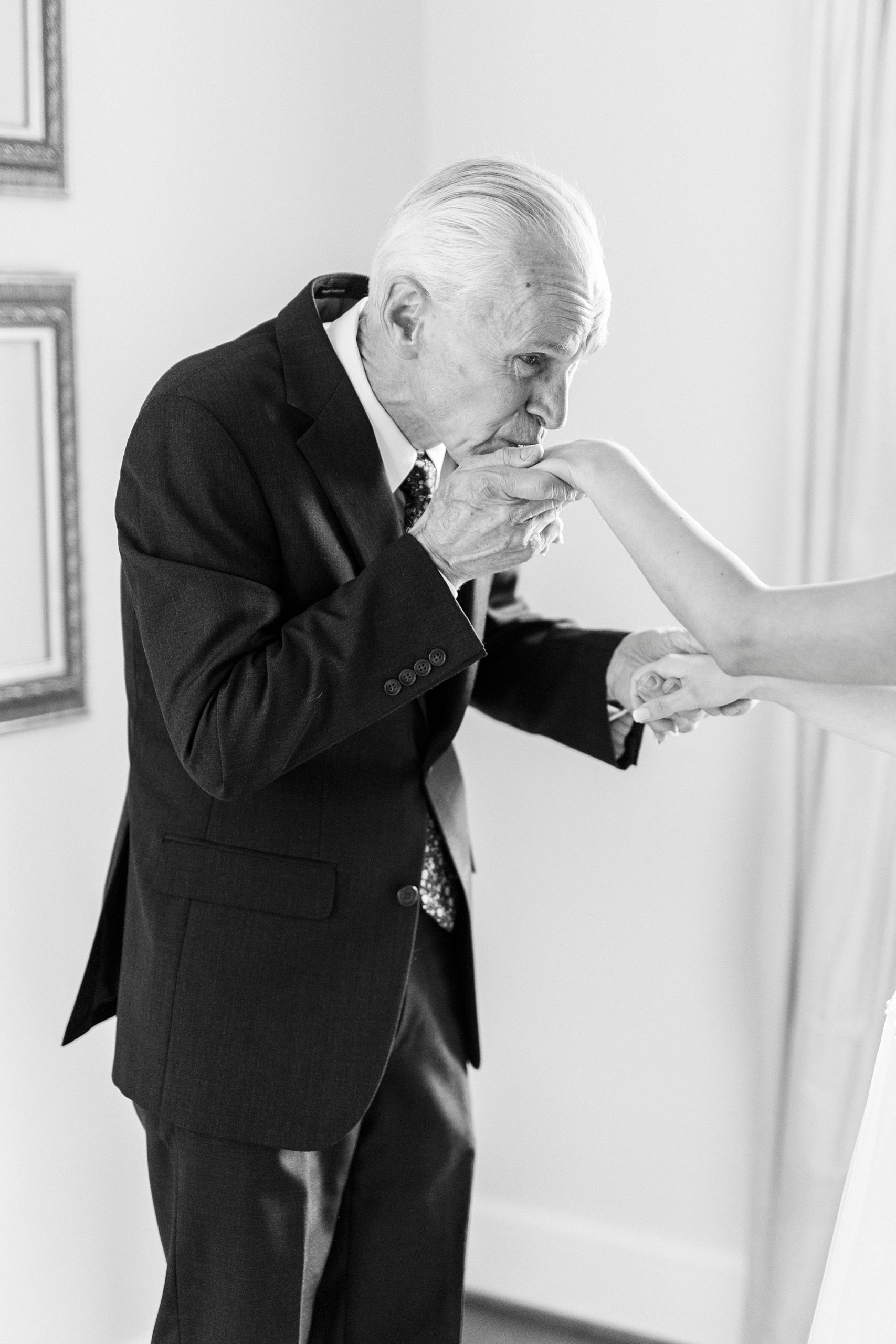 dad kisses bride's hand during first look at Boxwood Estate