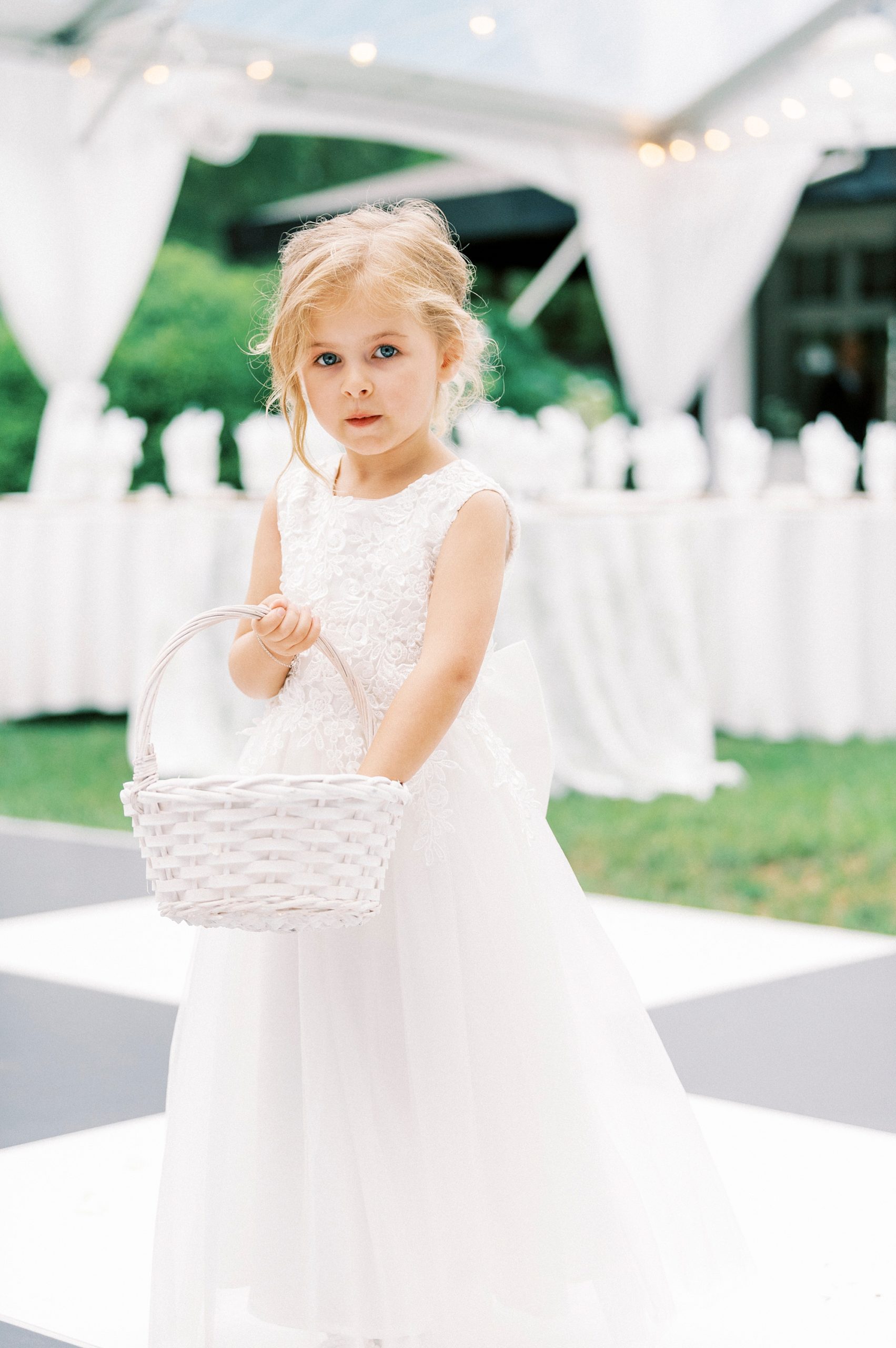 flower girl reaches in white basket on dance floor