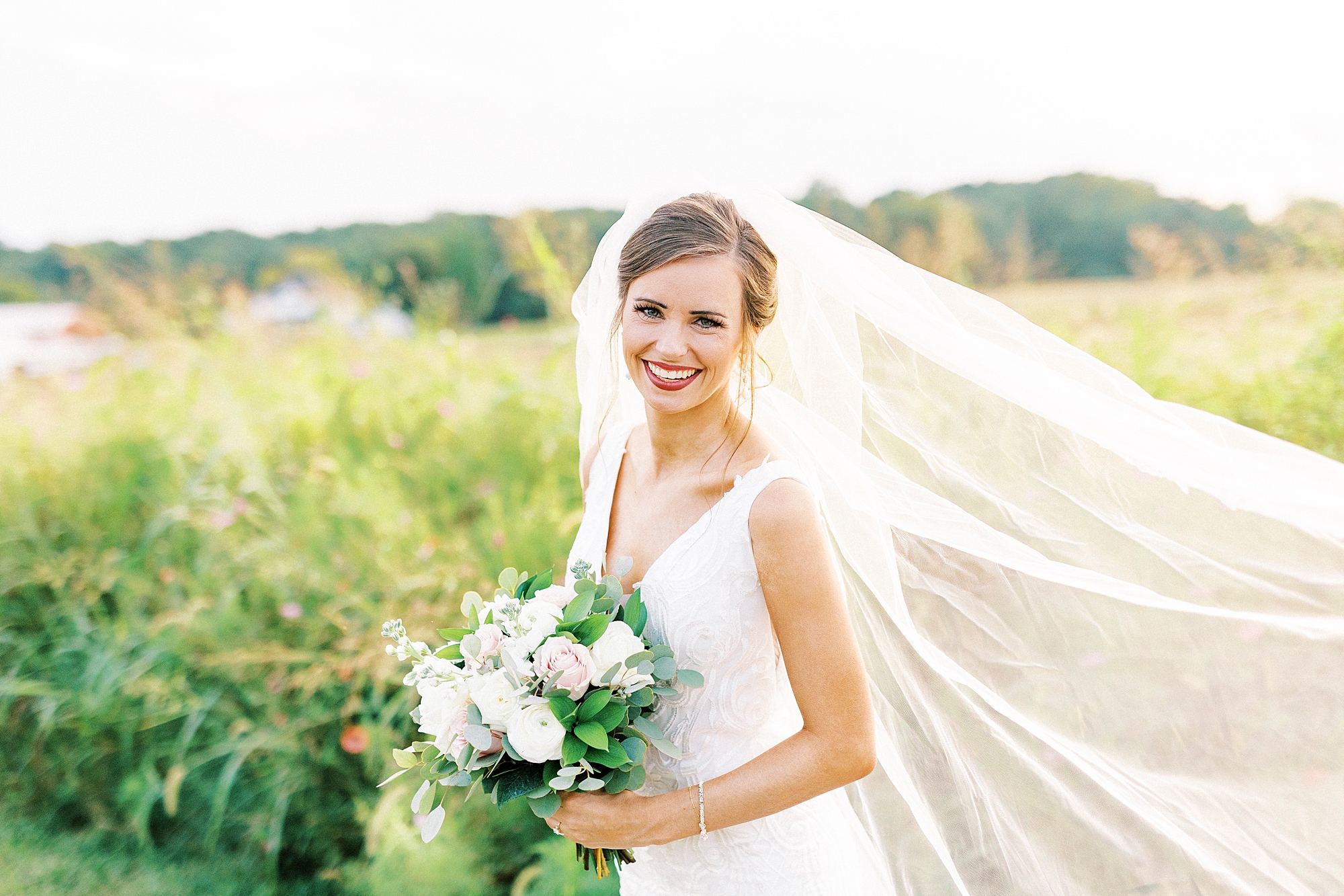 bridal portraits of bride with veil floating behind her 