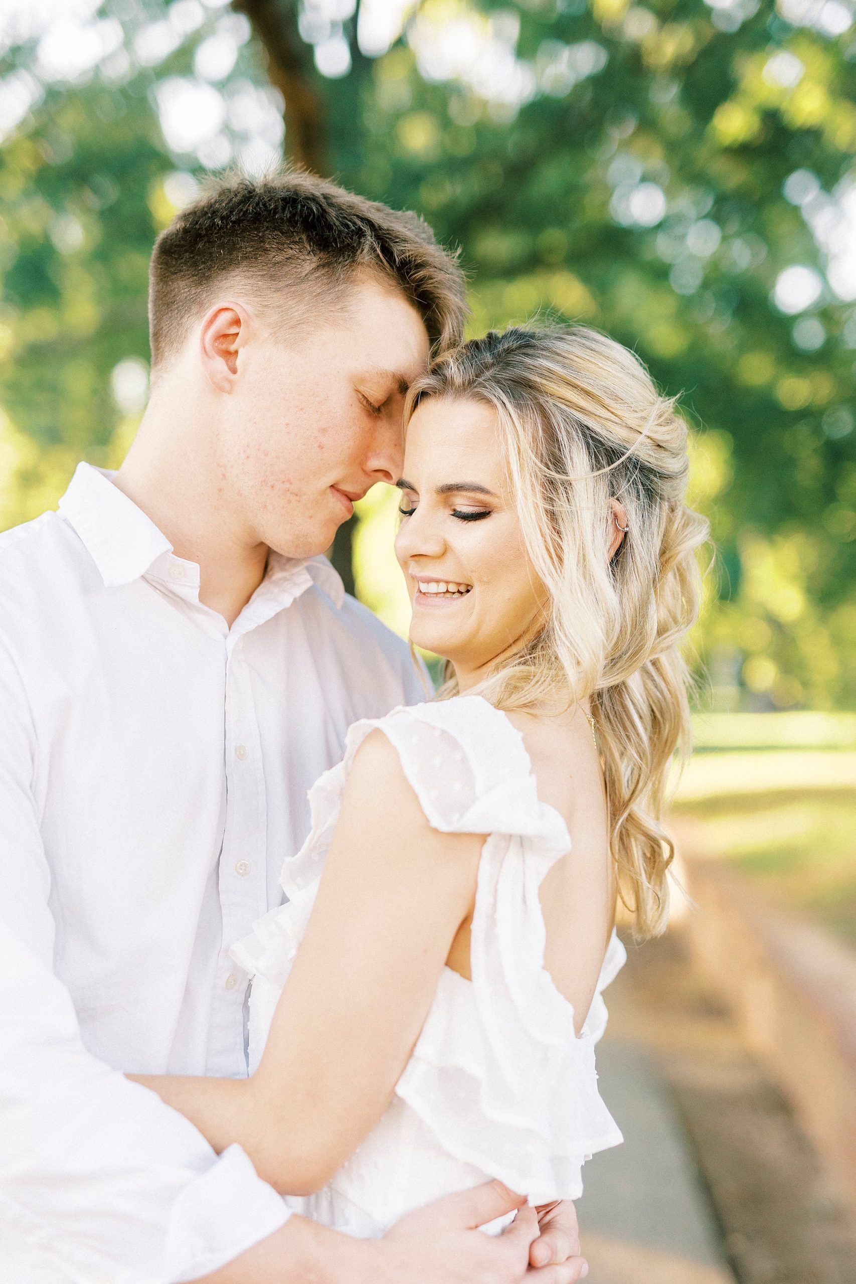 groom nuzzles bride's forehead while she looks over shoulder