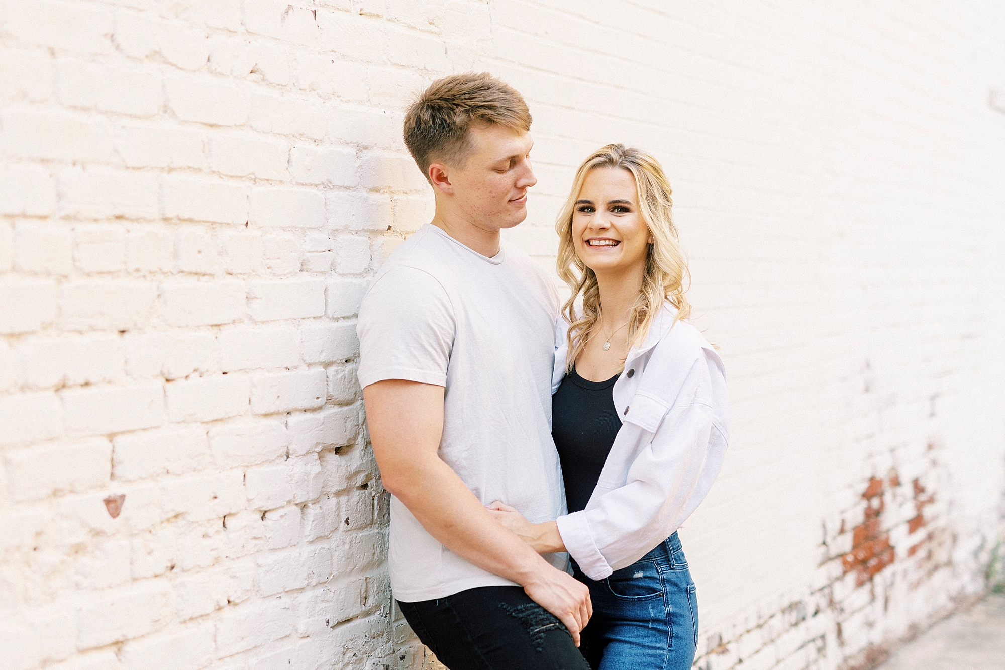 groom looks at bride during Downtown Concord engagement portraits