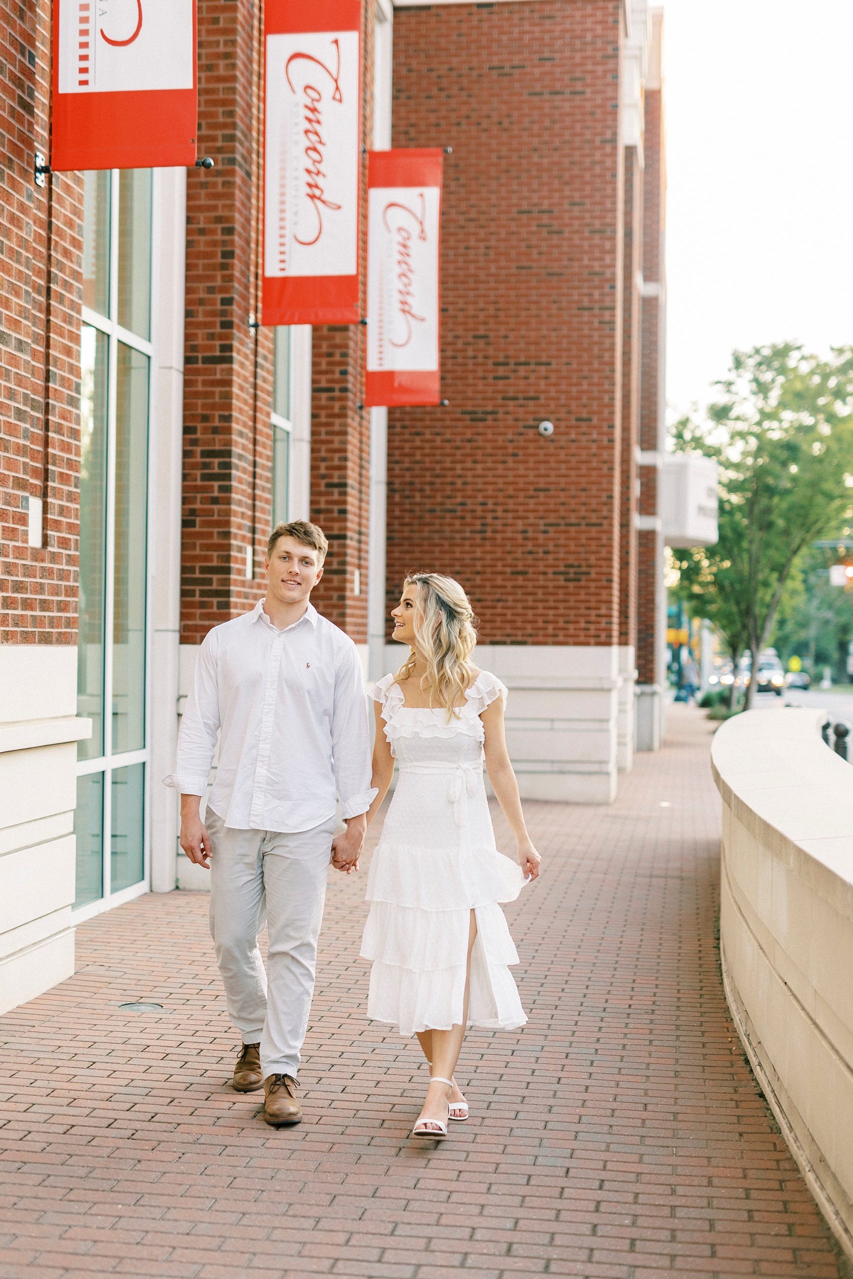 couple holds hands walking by police station in Concord NC