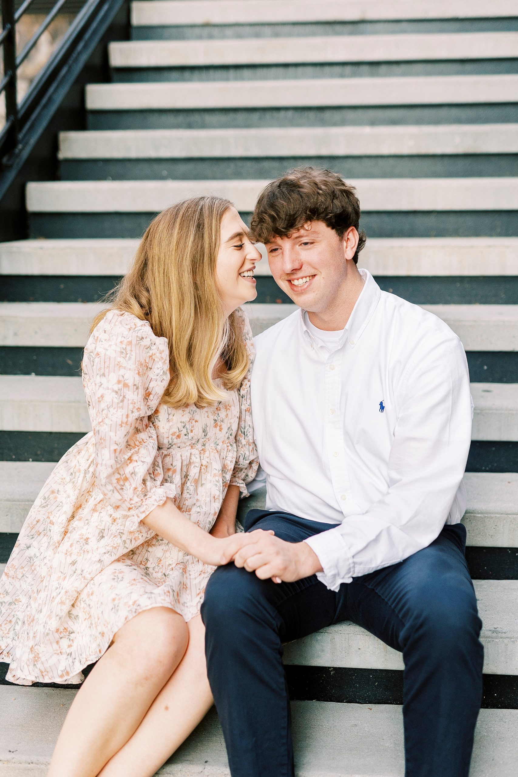 woman laughs on steps with fiancee at American Tobacco Campus