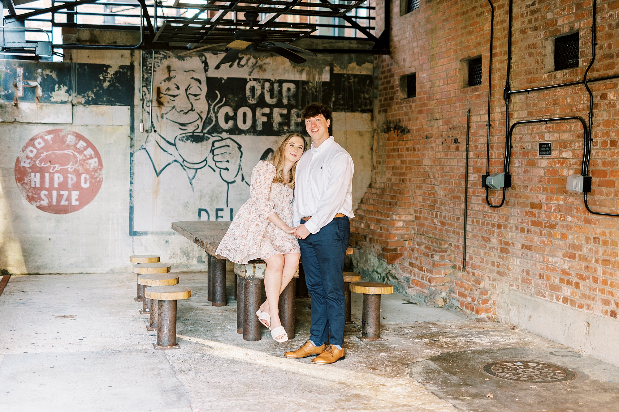 couple sits at table under warehouse at American Tobacco Campus