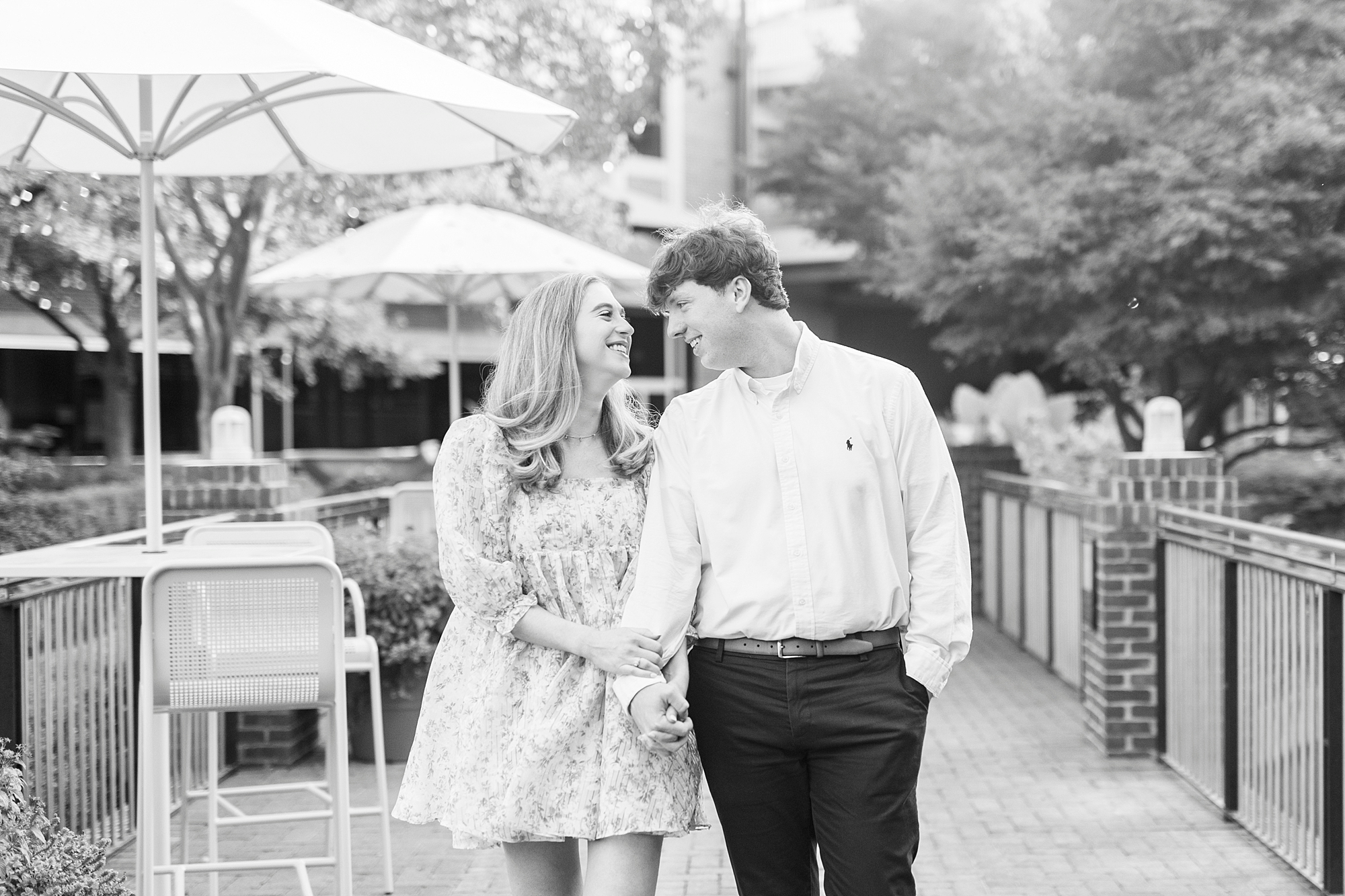 engaged couple holds hands smiling together at American Tobacco Campus