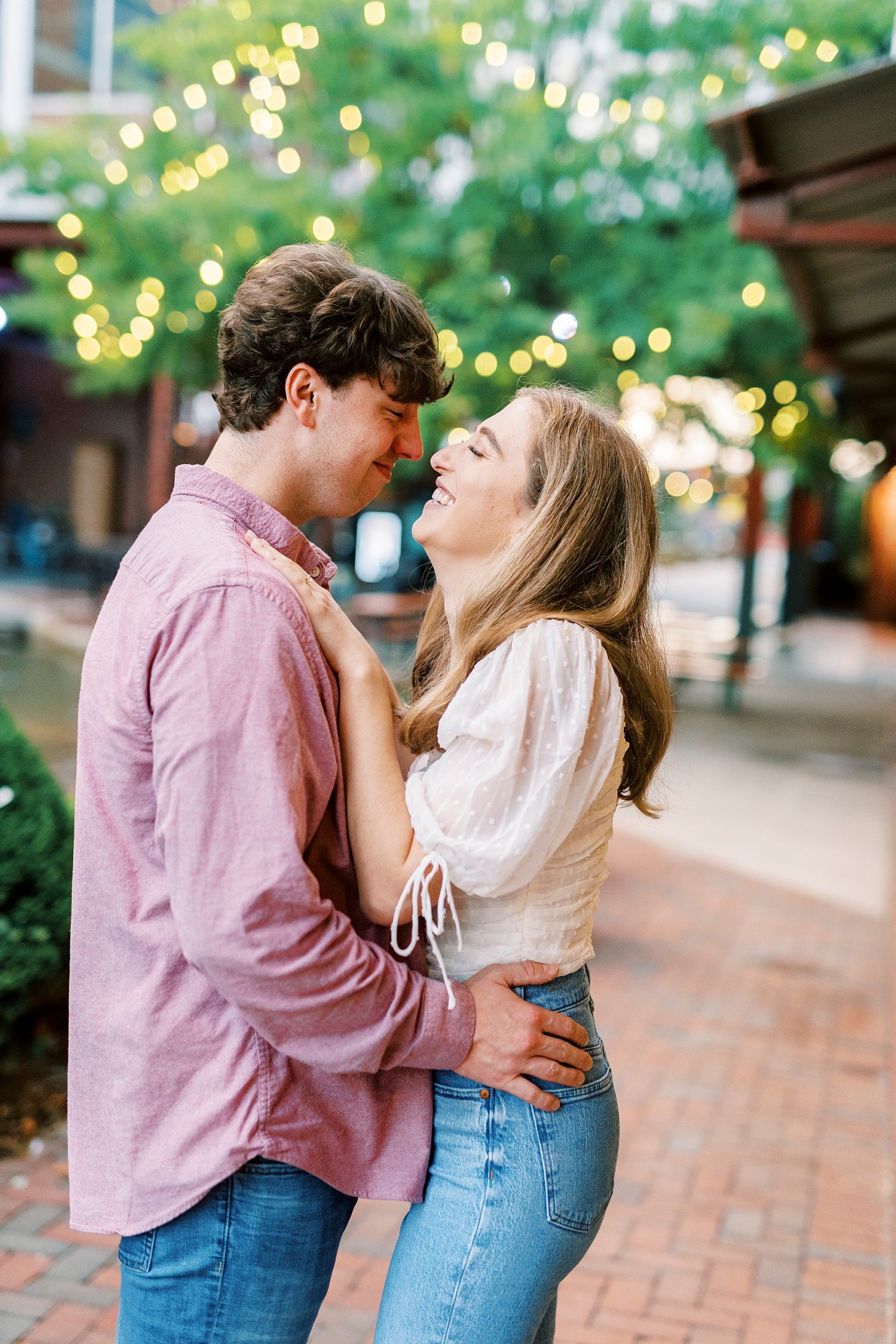 woman laughs with fiancee during engagement session in Durham NC