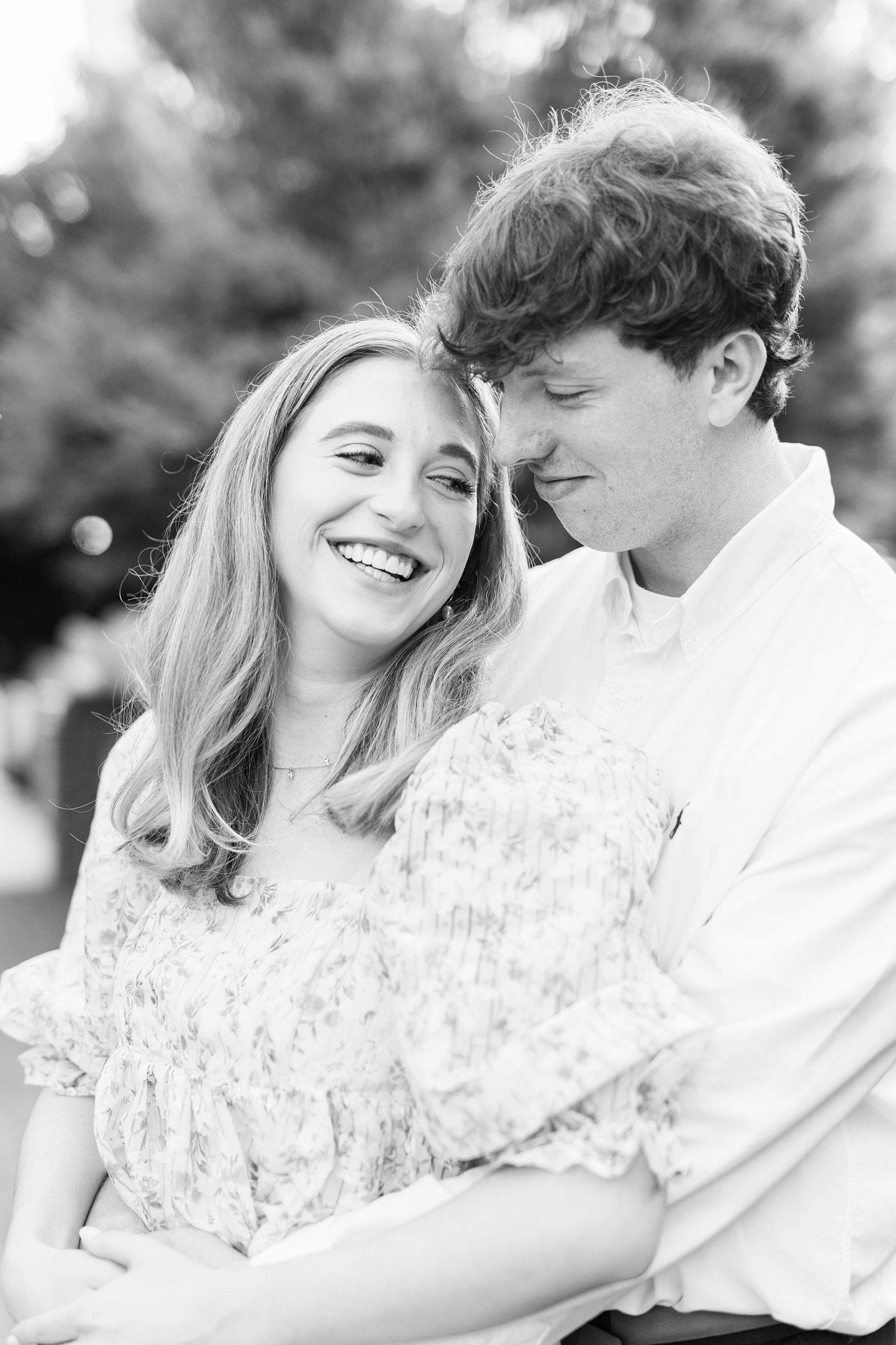bride laughs while groom hugs her from behind at the American Tobacco Campus
