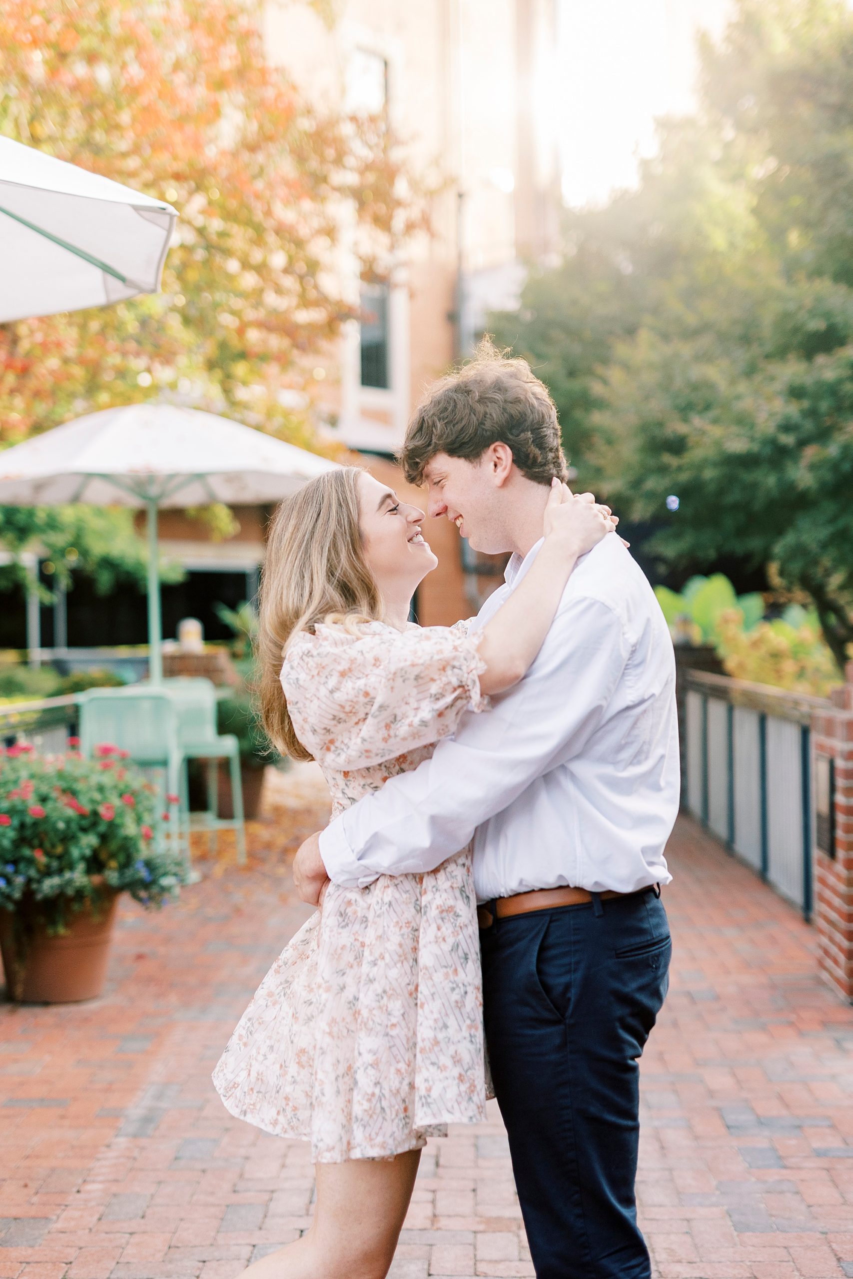 engaged couple hugs on patio at the American Tobacco Campus